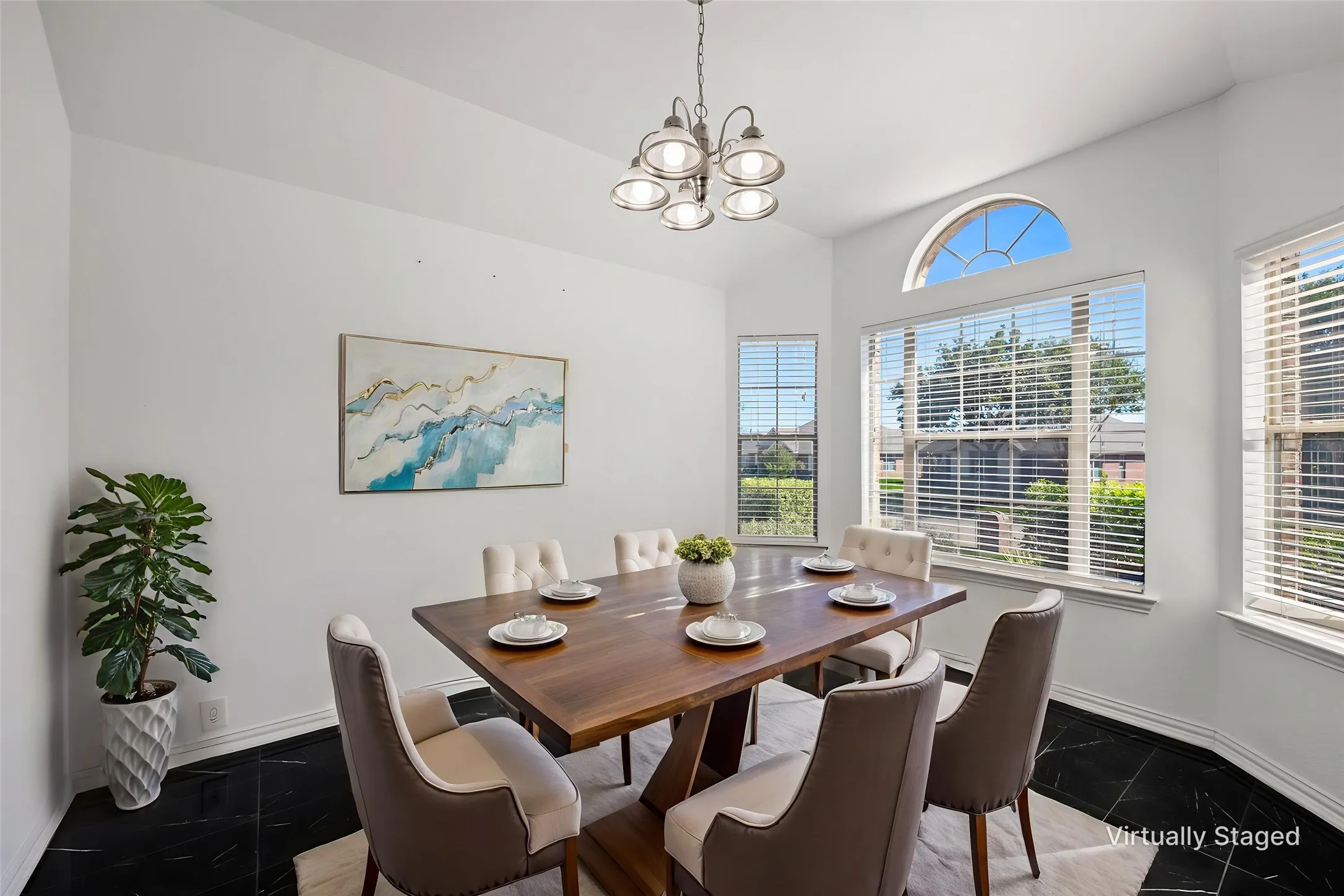 Bay window with an arched transom, sleek black tile flooring, and a modern chandelier