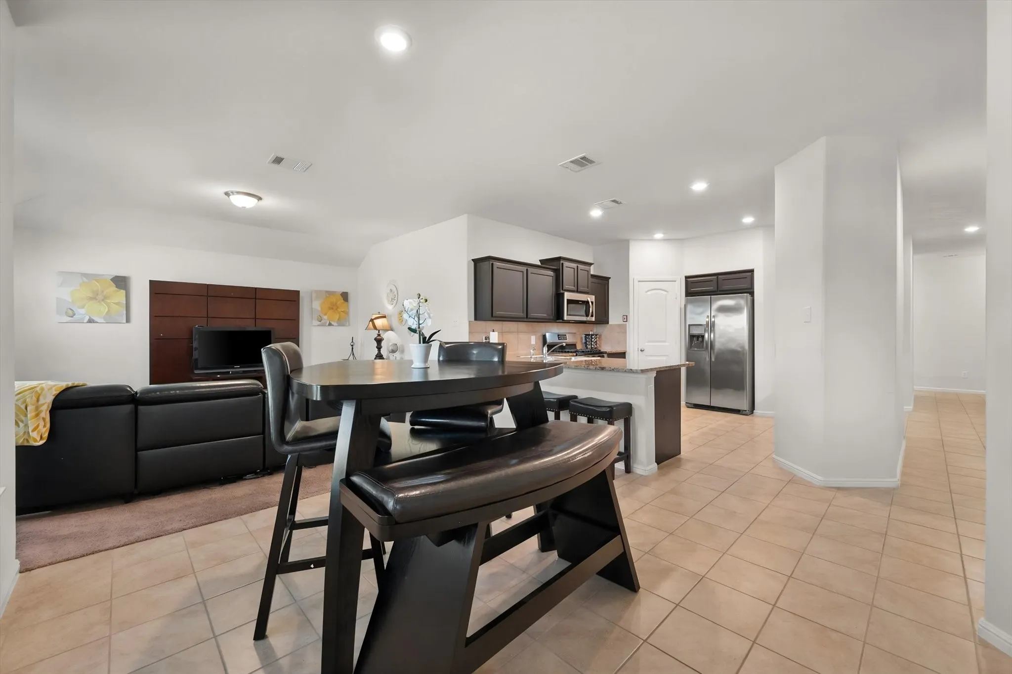 Kitchen with dark wood cabinetry, stainless steel appliances, and a light-colored countertop