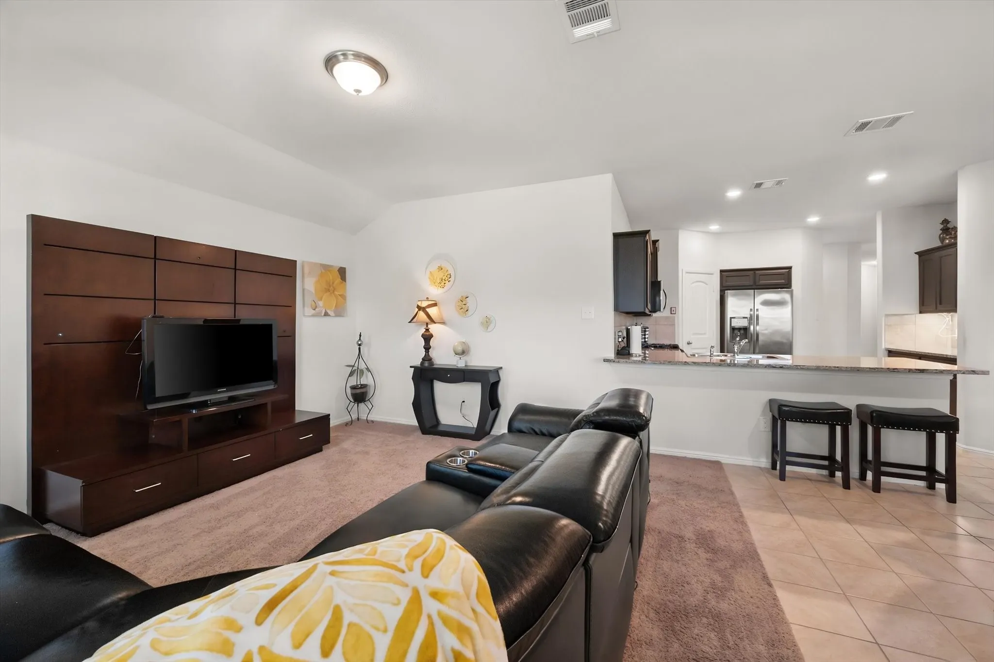 Open concept living area featuring a built-in media center, recessed lighting, and a breakfast bar