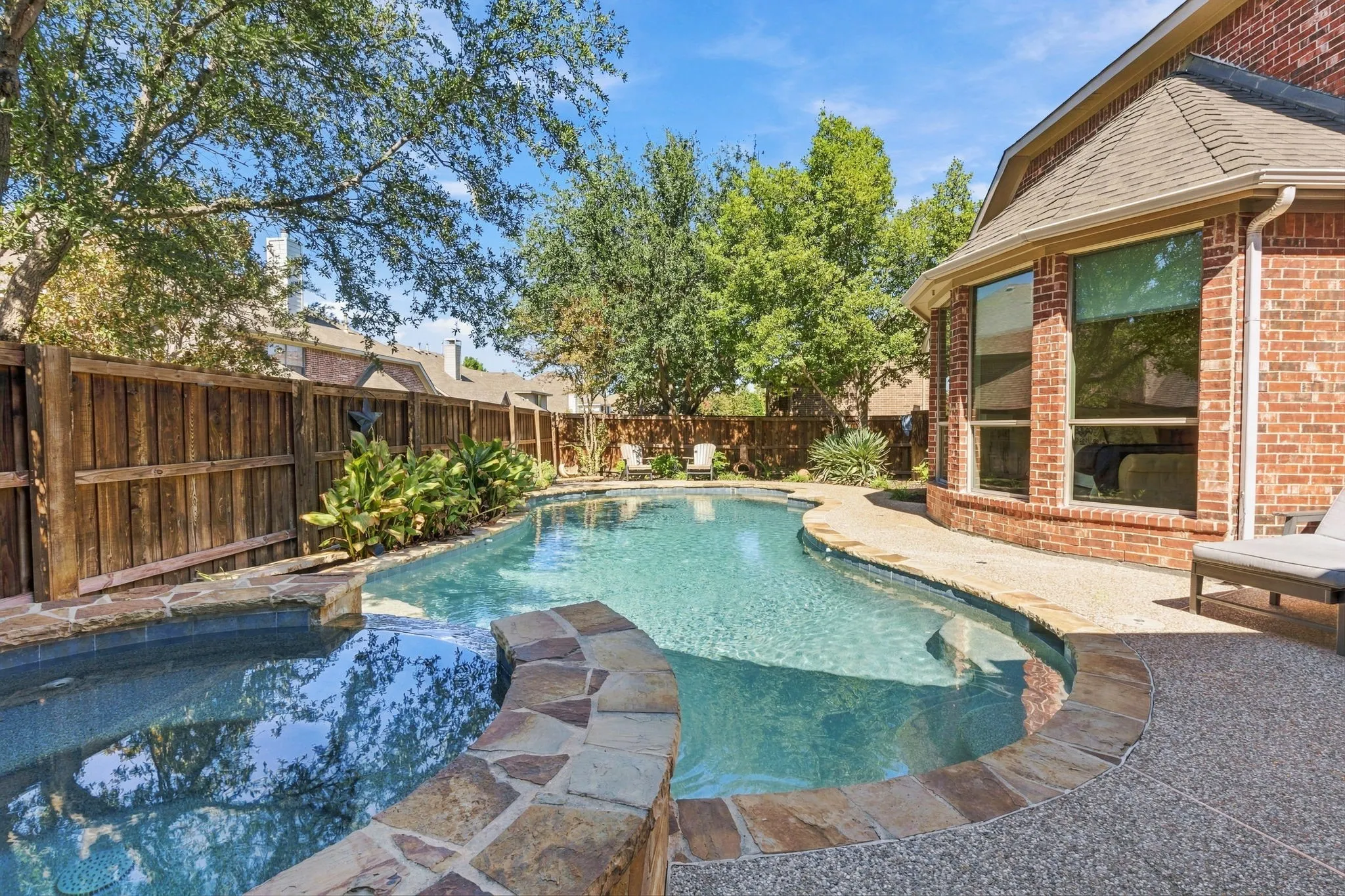 Backyard Pool and Spa | Heated gunite pool and spa with surrounding decking, mature landscaping and a fenced backyard.