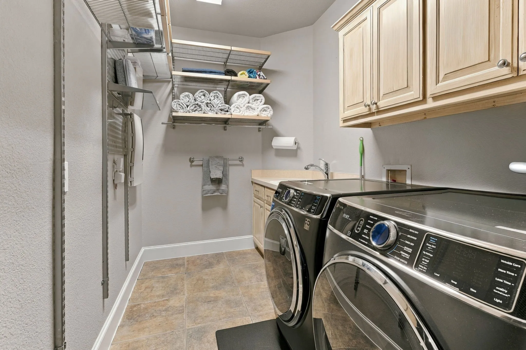 Laundry Room | Dedicated utility space with upper cabinets, hanging space and side-by-side laundry connections.