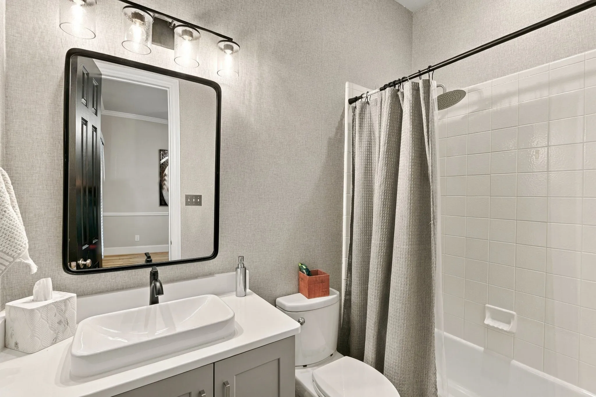 Main-Level Full Bathroom | Full bath with a vanity and tub-shower combination serves the downstairs secondary bedroom and nearby living areas.