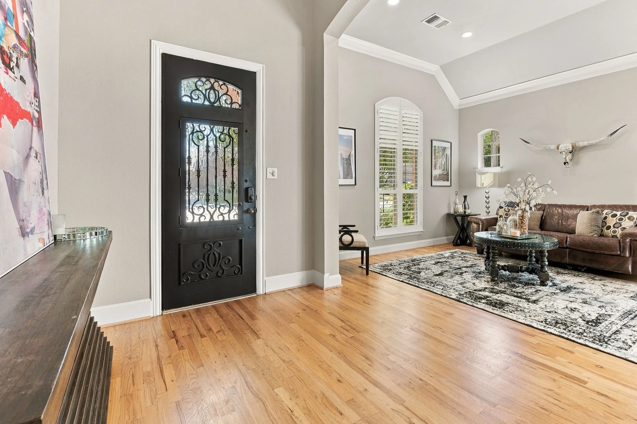 Entrance Foyer | Wood flooring, a decorative glass front door and open sightlines to the formal living room create a welcoming main-level entry.