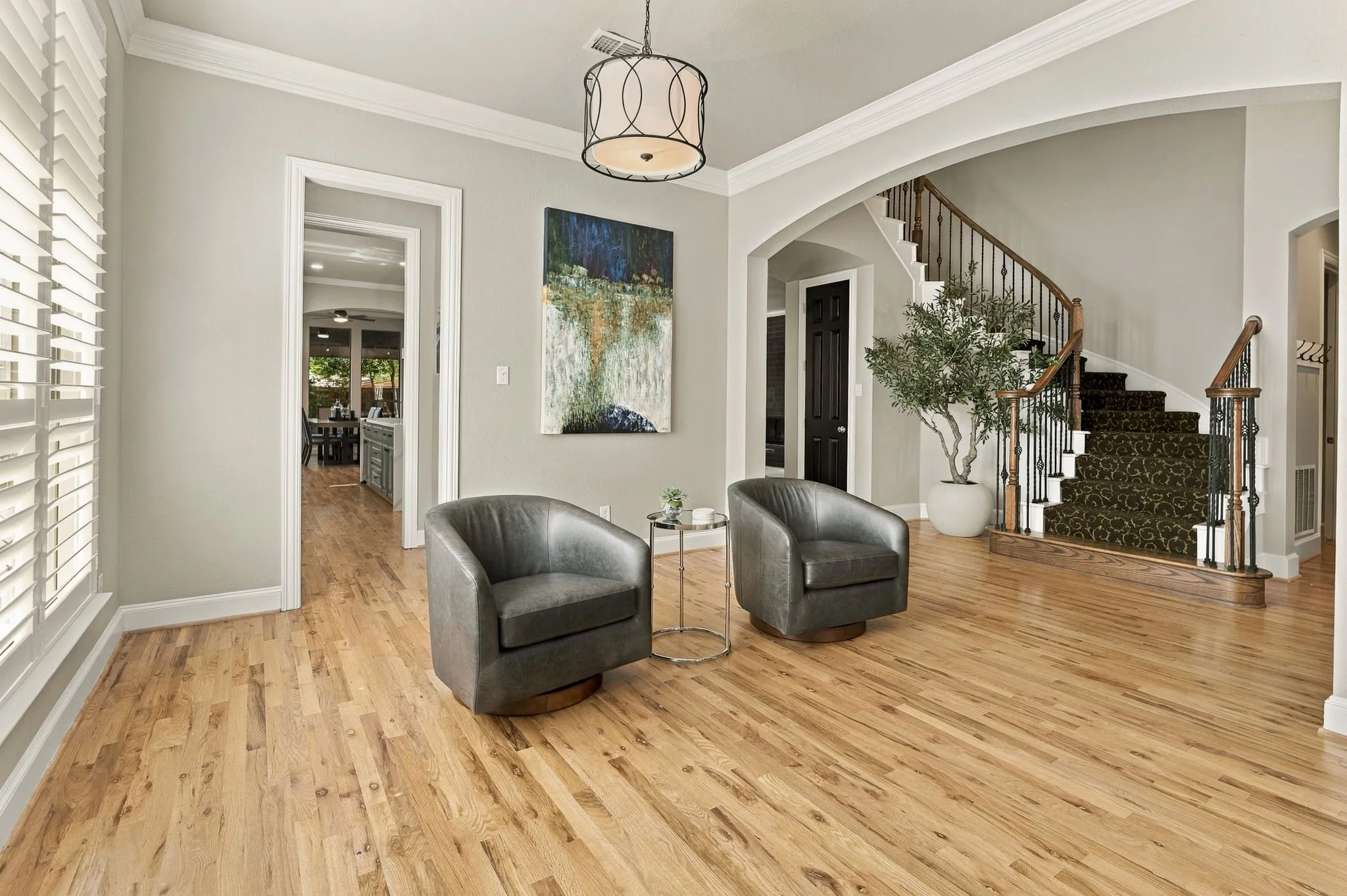 Formal Dining Room, Alternate View | Currently furnished as a sitting room, this flexible space features crown molding, wood floors and an arched connection to the formal living room.