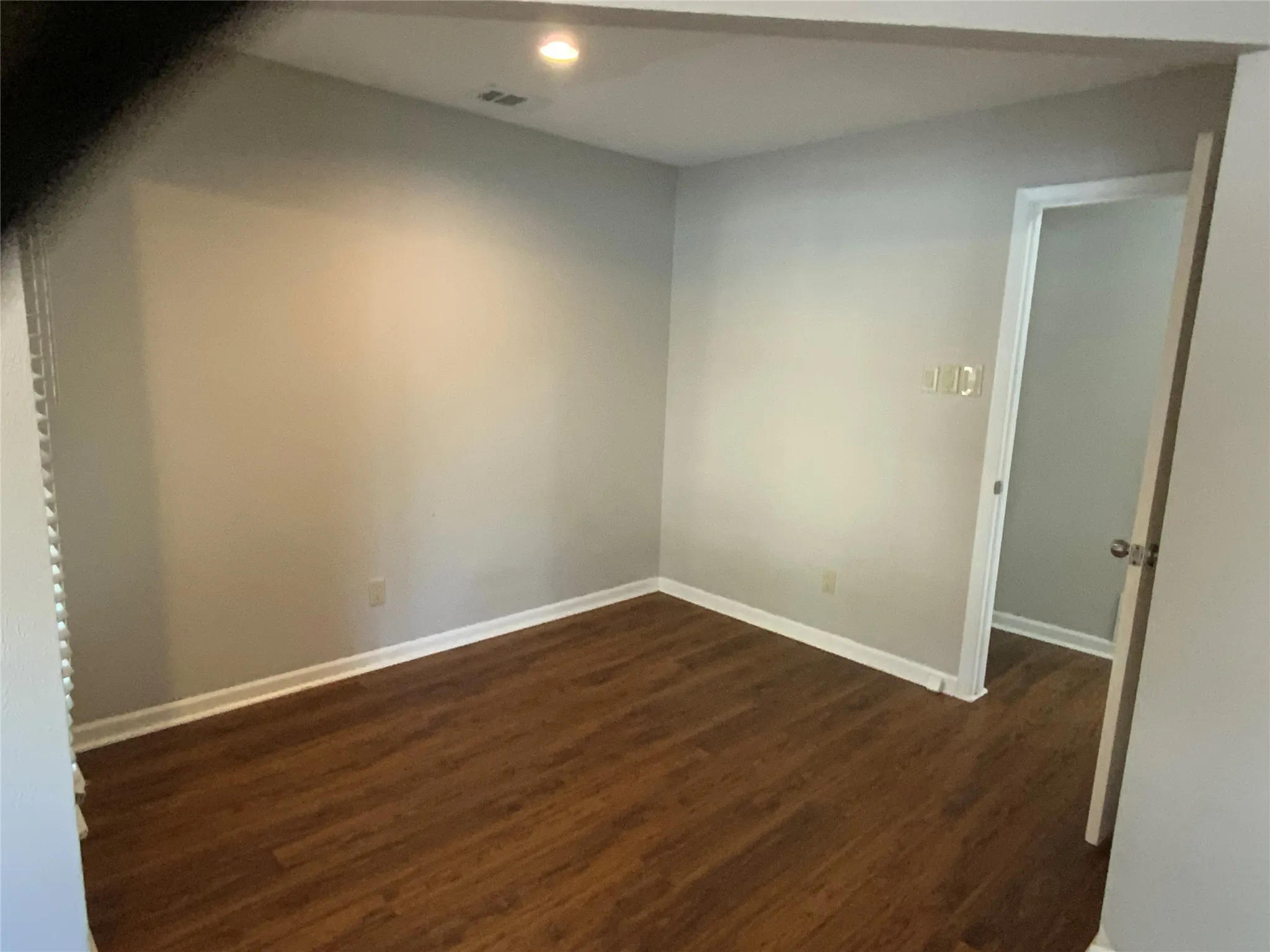 Wood-finish flooring with white baseboards and light gray walls