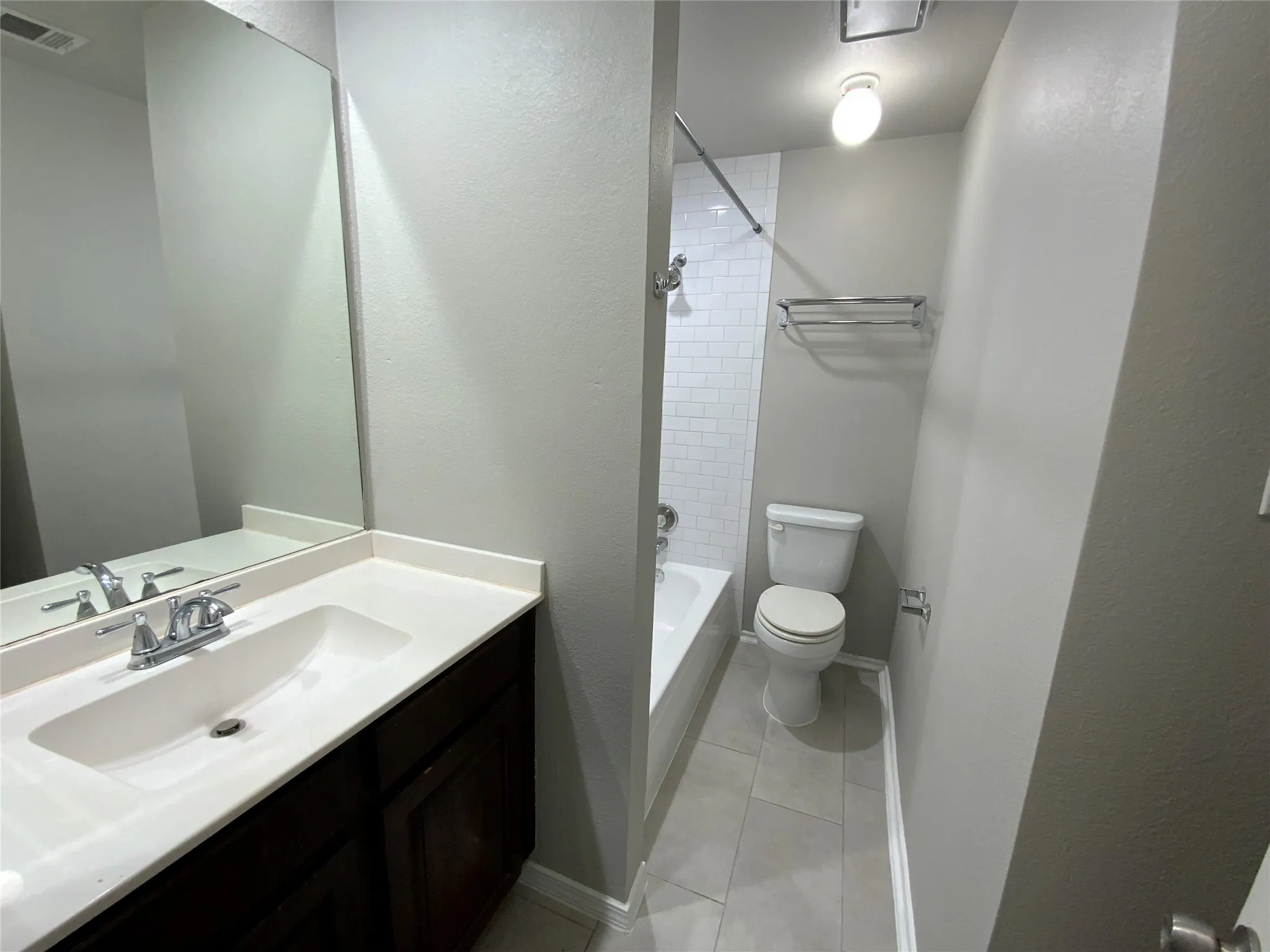 Bathroom featuring a vanity with an integrated sink, polished chrome faucet, and a large wall-mounted mirror