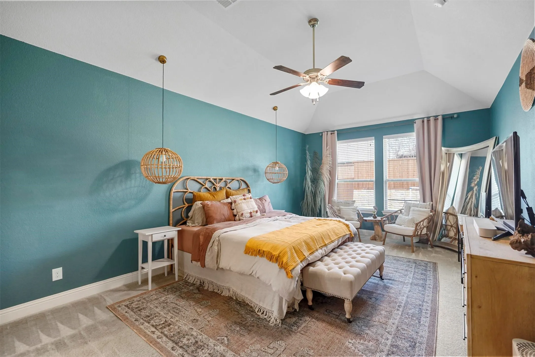 Vaulted ceiling with a ceiling fan, dual windows with blinds, and pendant lighting