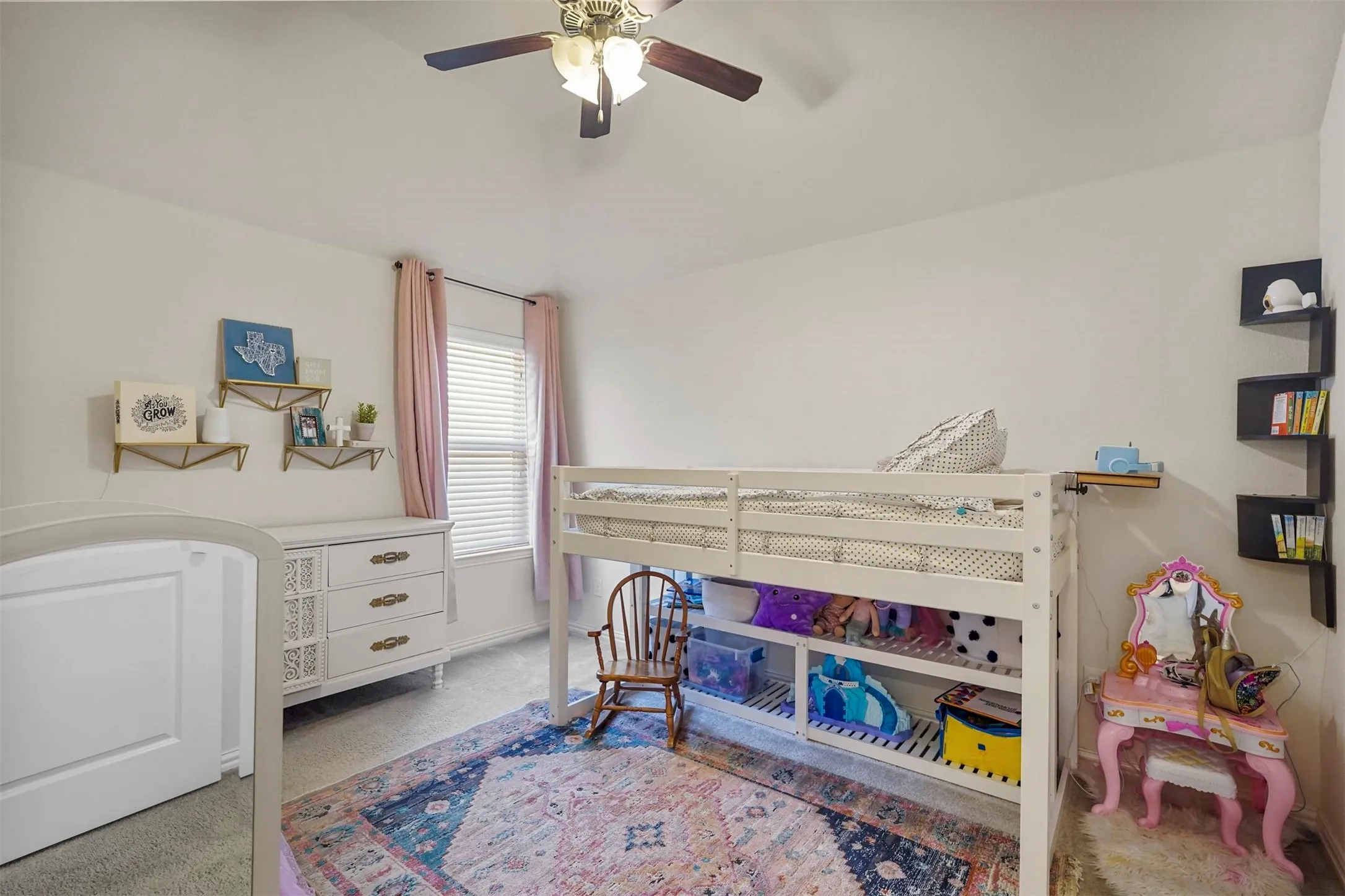 Vaulted ceiling with a ceiling fan, white walls, and a window with blinds