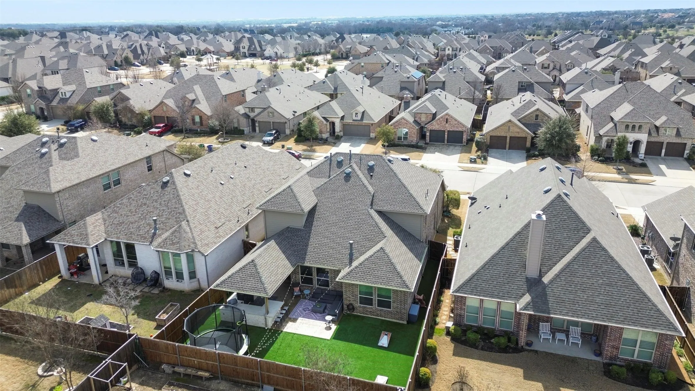 Backyard featuring an artificial turf lawn, concrete patio, and wood privacy fencing
