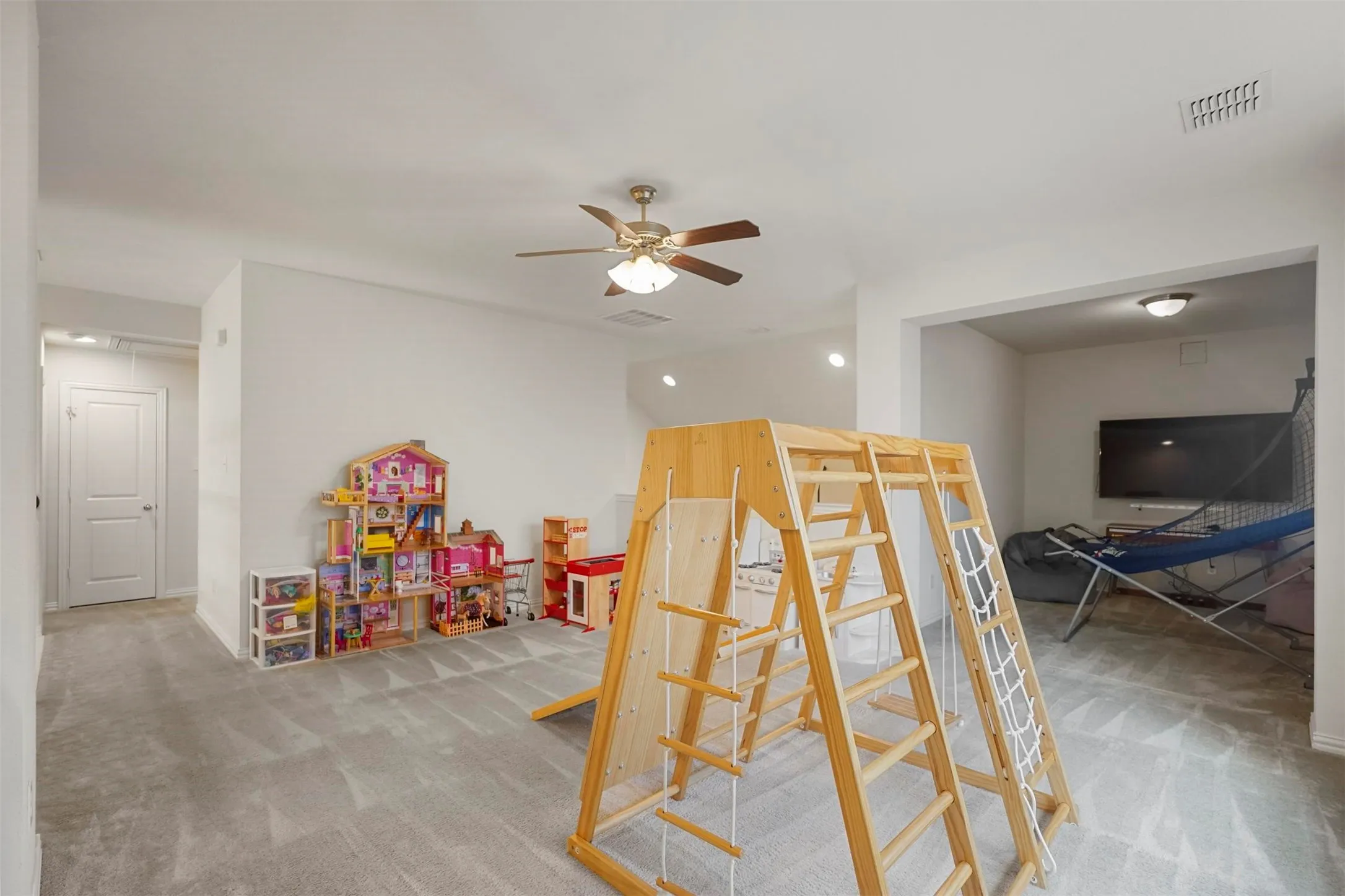 Spacious interior with neutral carpeting, recessed lighting, and a ceiling fan