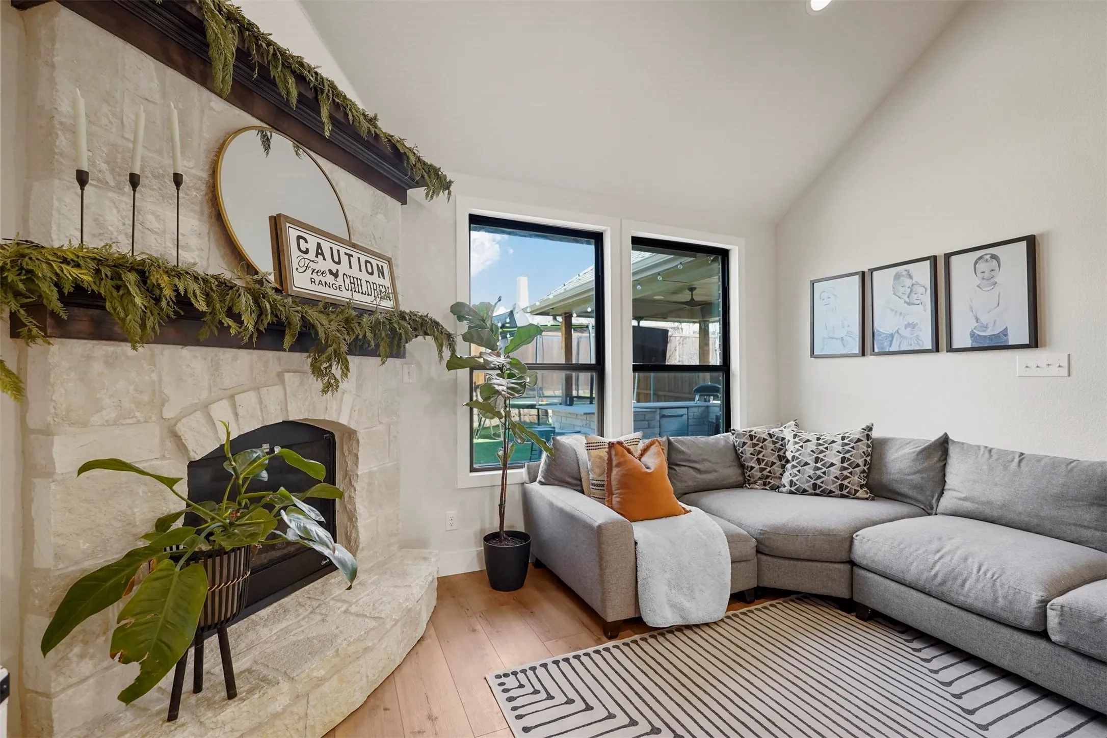 Vaulted ceiling with a stone-clad fireplace and dark wood mantle