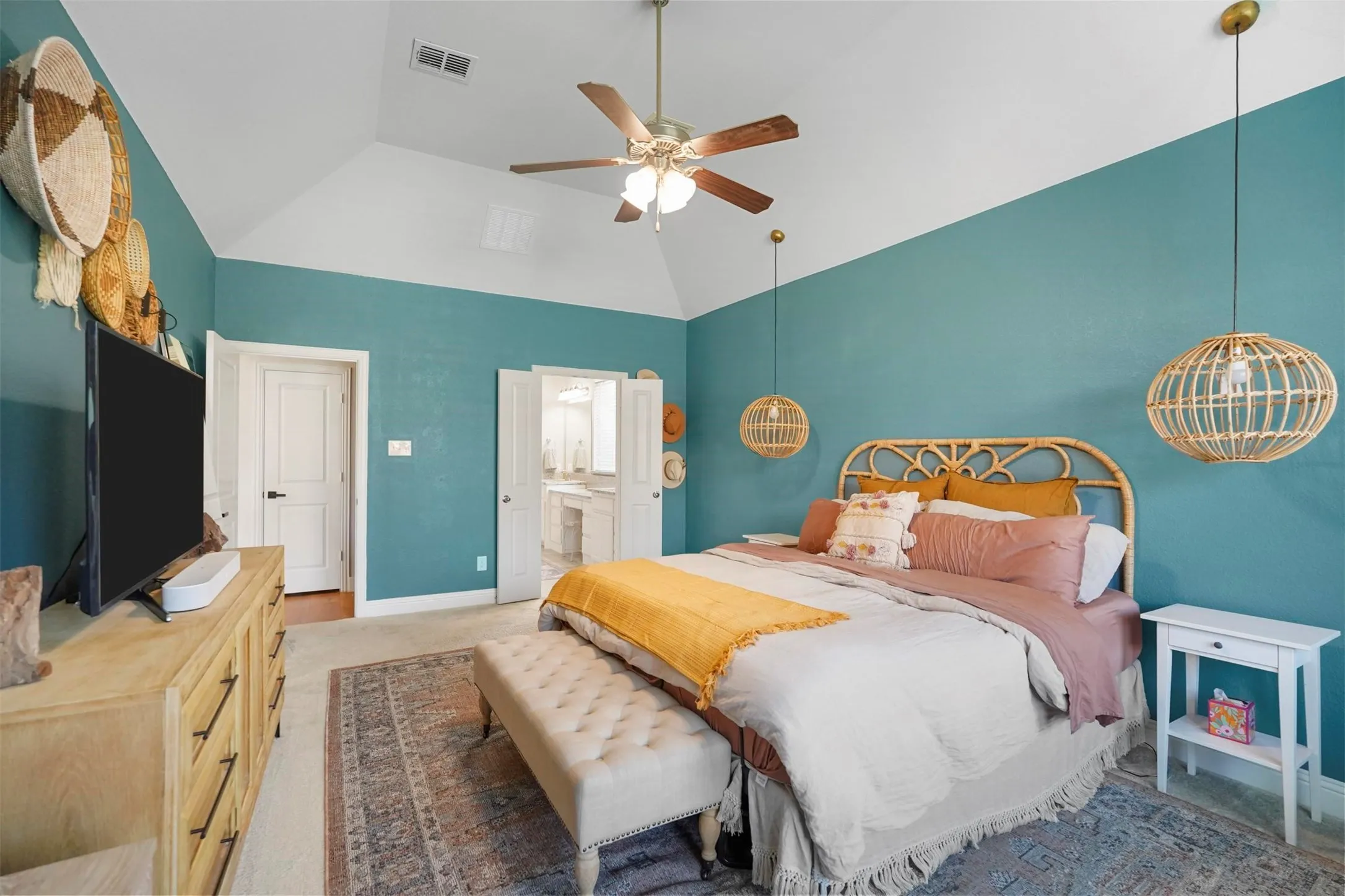 Vaulted ceiling with a ceiling fan, dual pendant lighting, and a neutral carpeted floor