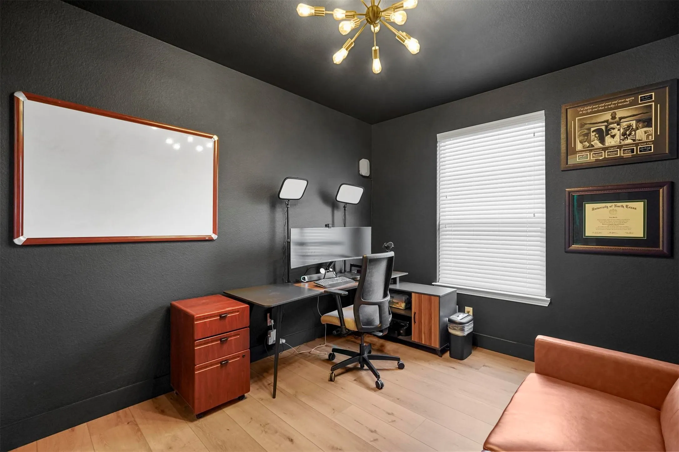 Wood-finish flooring, dark wall finishes, and a modern sputnik-style light fixture