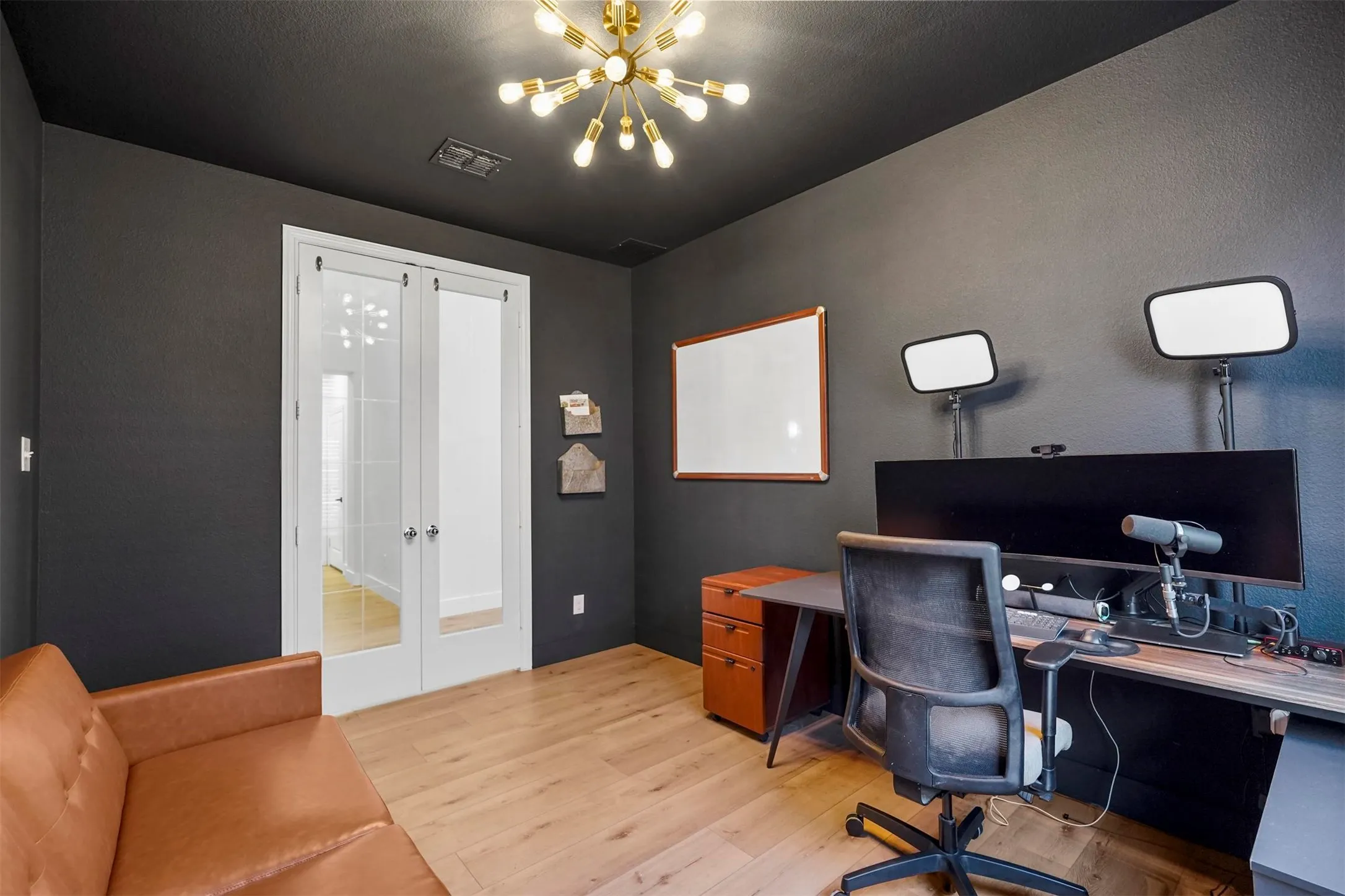 Light wood-finish flooring with dark painted walls