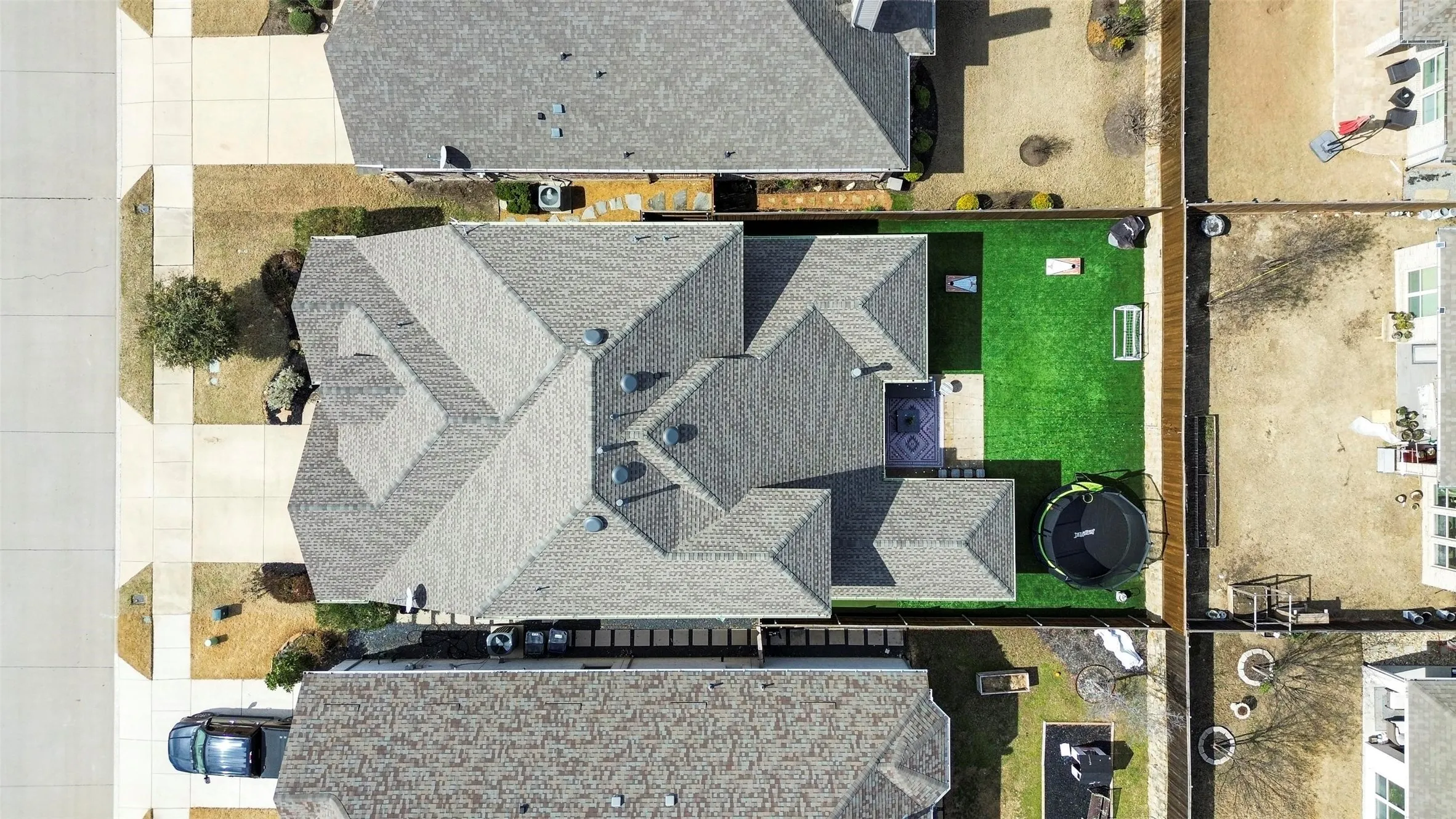 Expansive backyard featuring a manicured lawn, paved patio, and privacy fencing