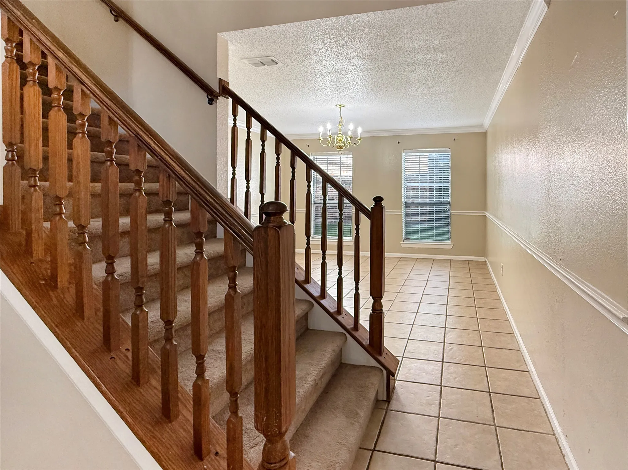 Staircase with wood balusters and carpeted treads
