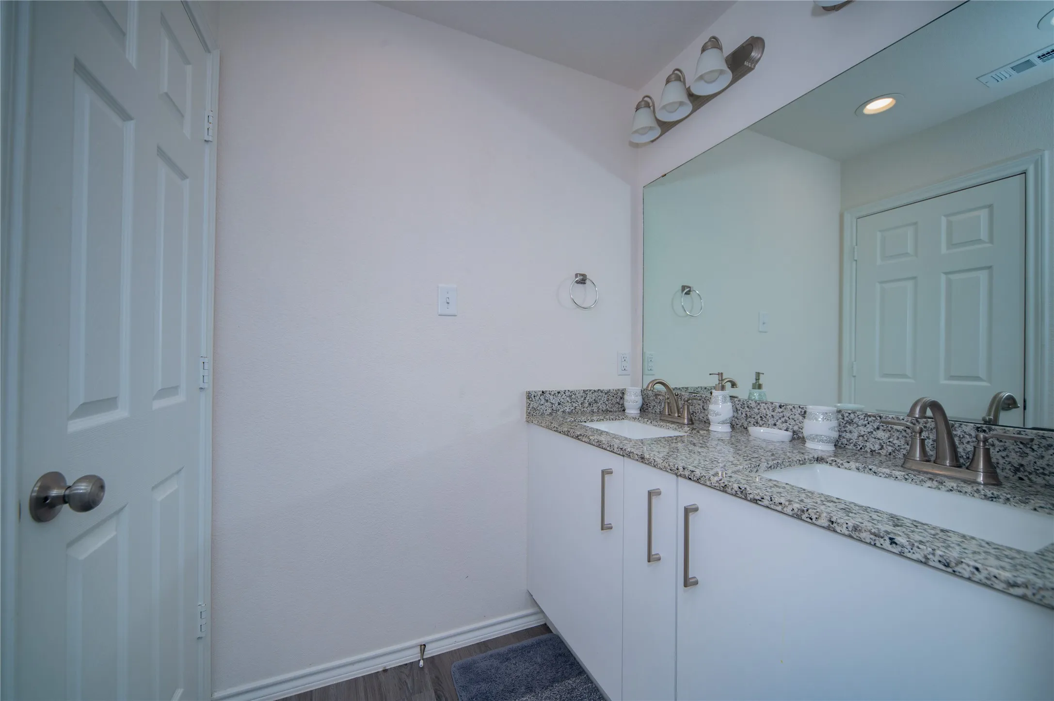 Dual vanity with stone-finish countertops, undermount sinks, and brushed nickel fixtures