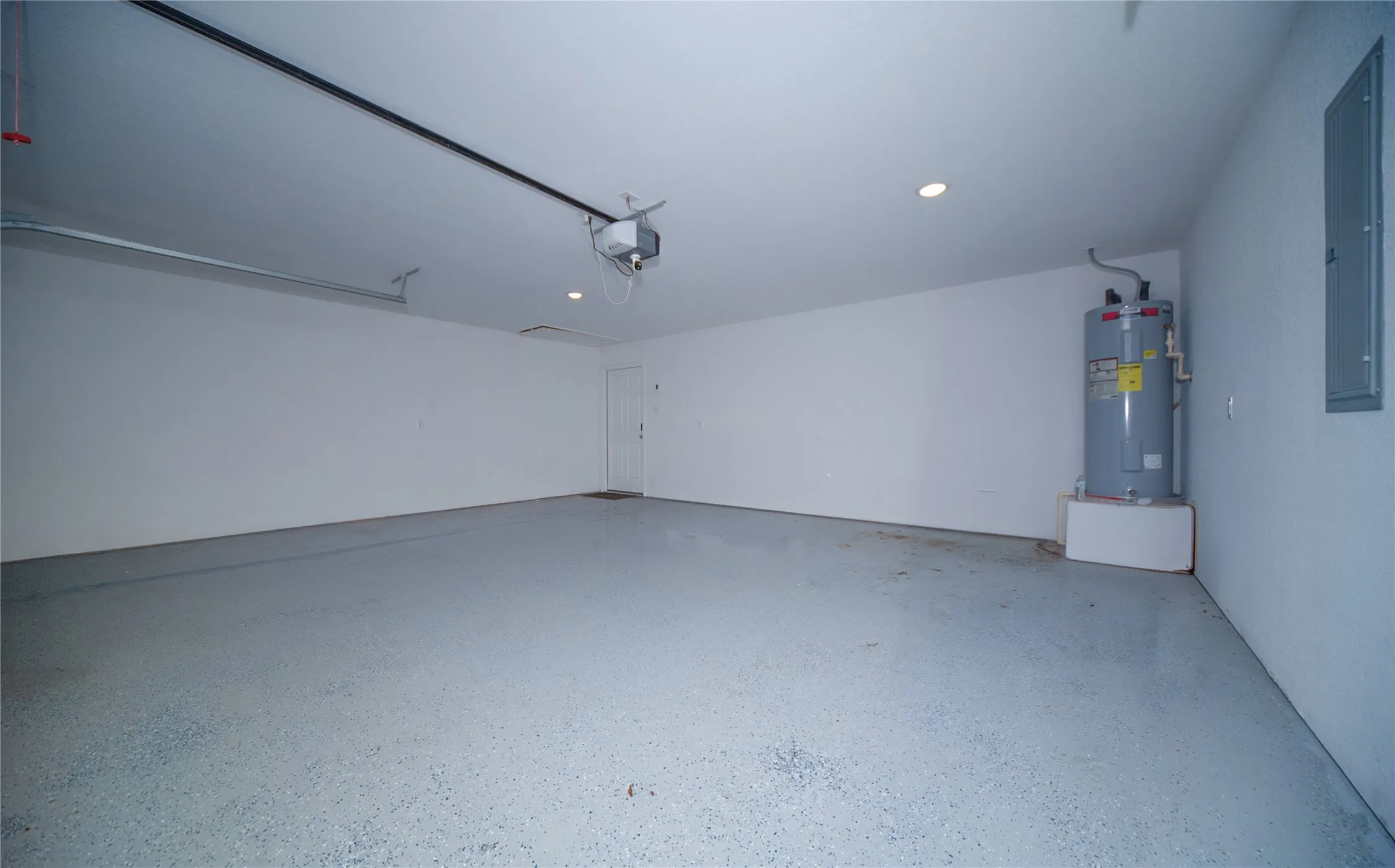 Spacious garage with an epoxy floor, recessed lighting, and a built-in water heater