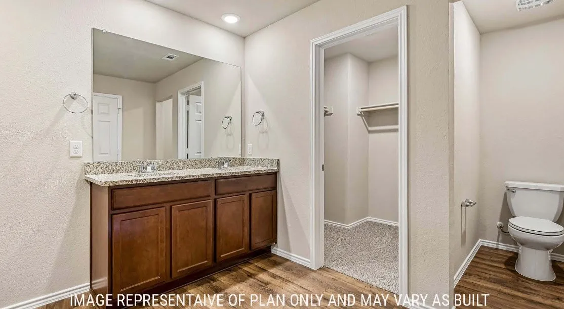 Double vanity with a speckled countertop, undermount sinks, and wood-finish cabinetry