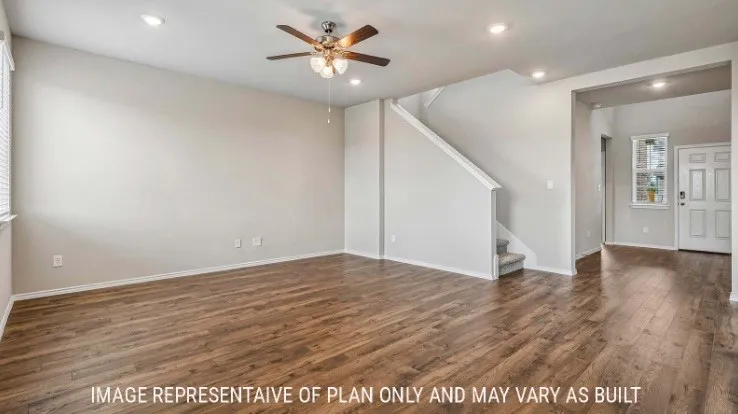 Wood-finish flooring throughout the main living area, recessed lighting, and a ceiling fan with integrated light fixture