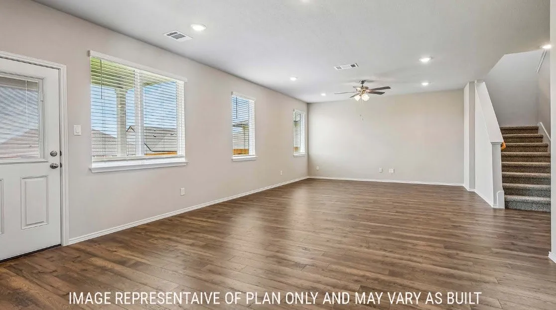Spacious living area featuring wood-finish flooring, recessed lighting, and a ceiling fan
