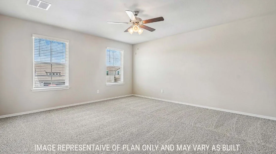 Neutral wall paint, textured carpet flooring, two windows with blinds, and a ceiling fan with integrated lighting