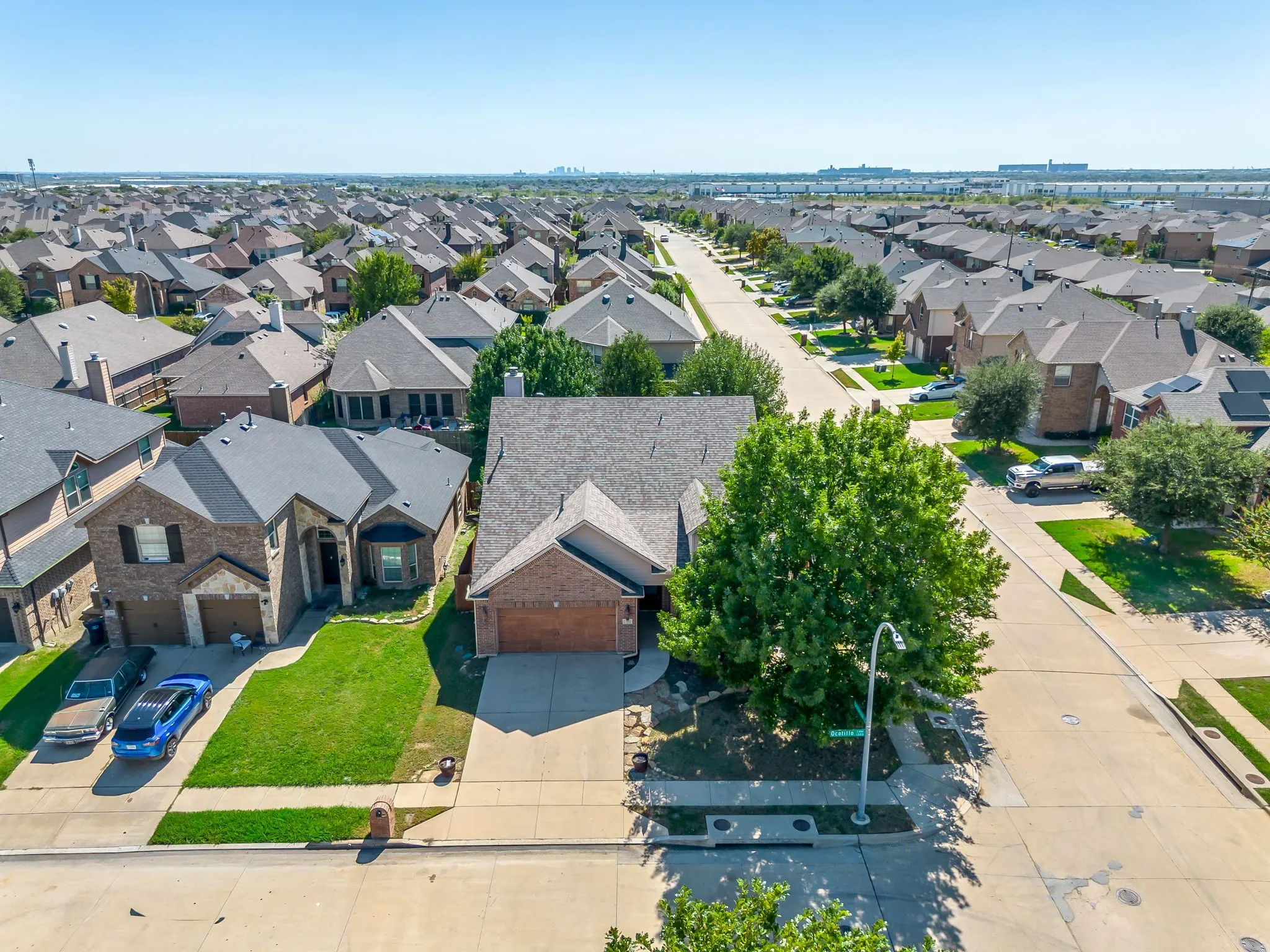 Brick exterior residence with an attached two-car garage, concrete driveway, and front lawn