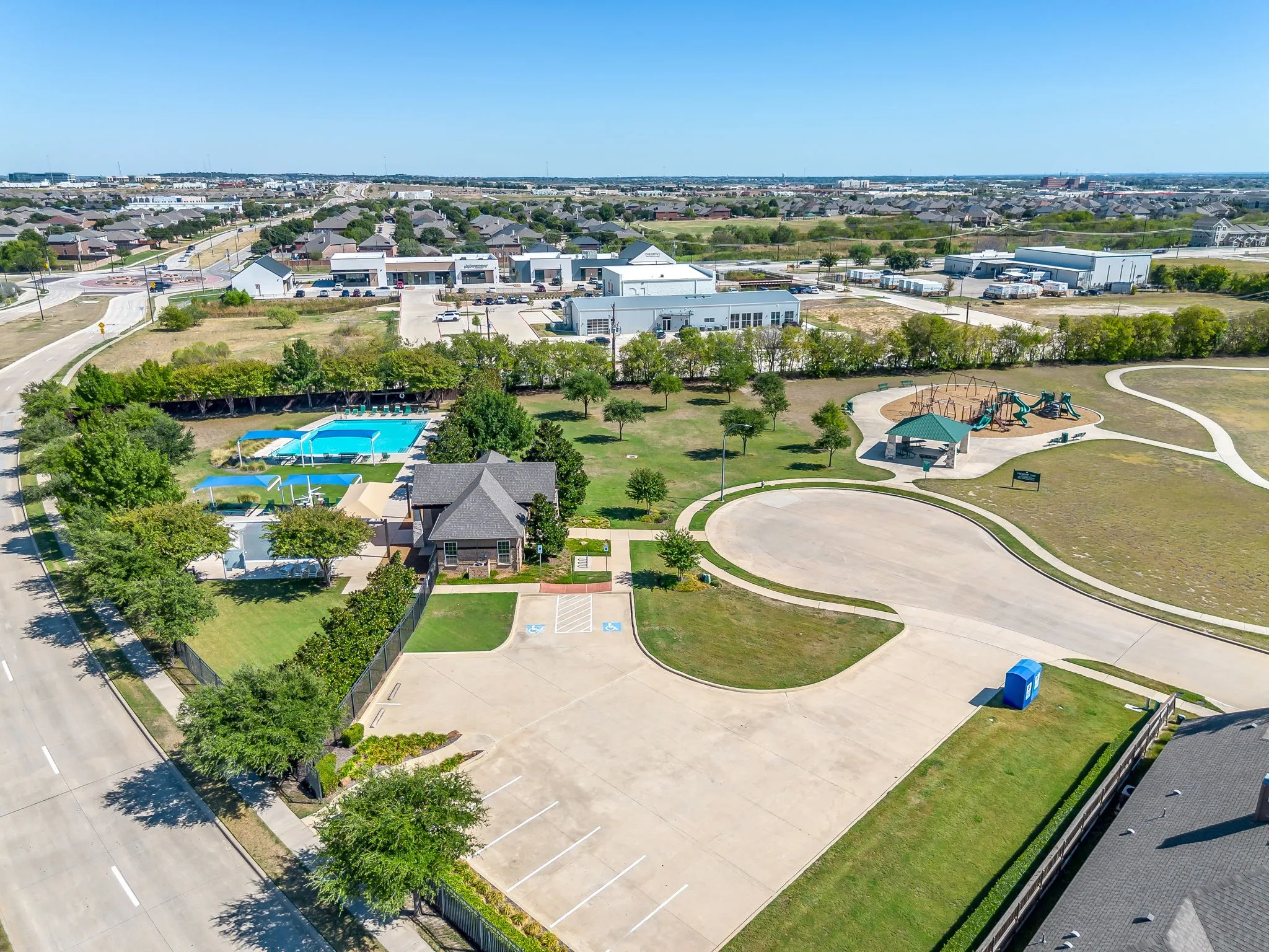 Community amenities featuring an outdoor swimming pool, shaded pool deck, clubhouse, and playground
