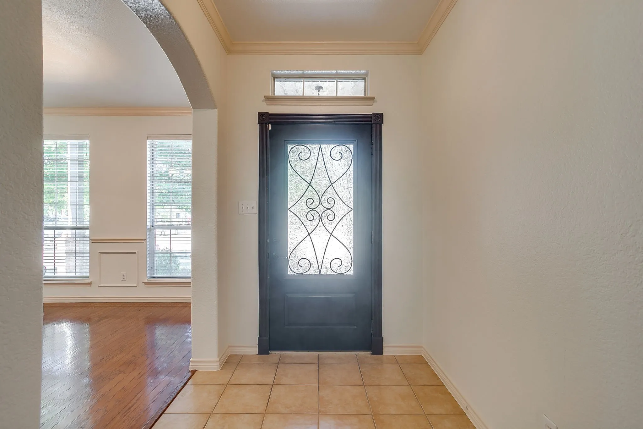 Decorative glass entry door with transom window and crown molding