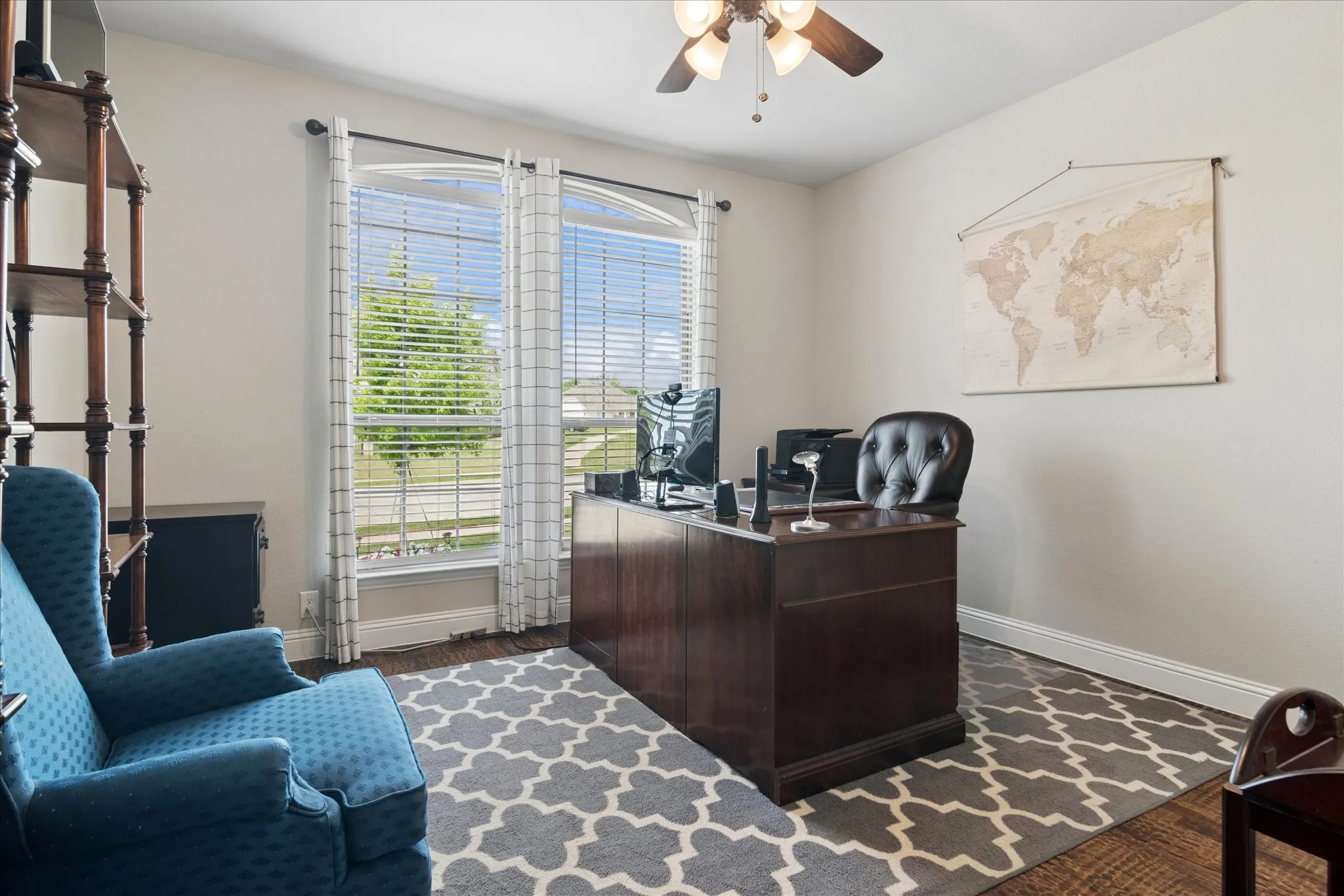 Sophisticated home office featuring a dark wood executive desk, black leather chair, and built-in cabinetry
