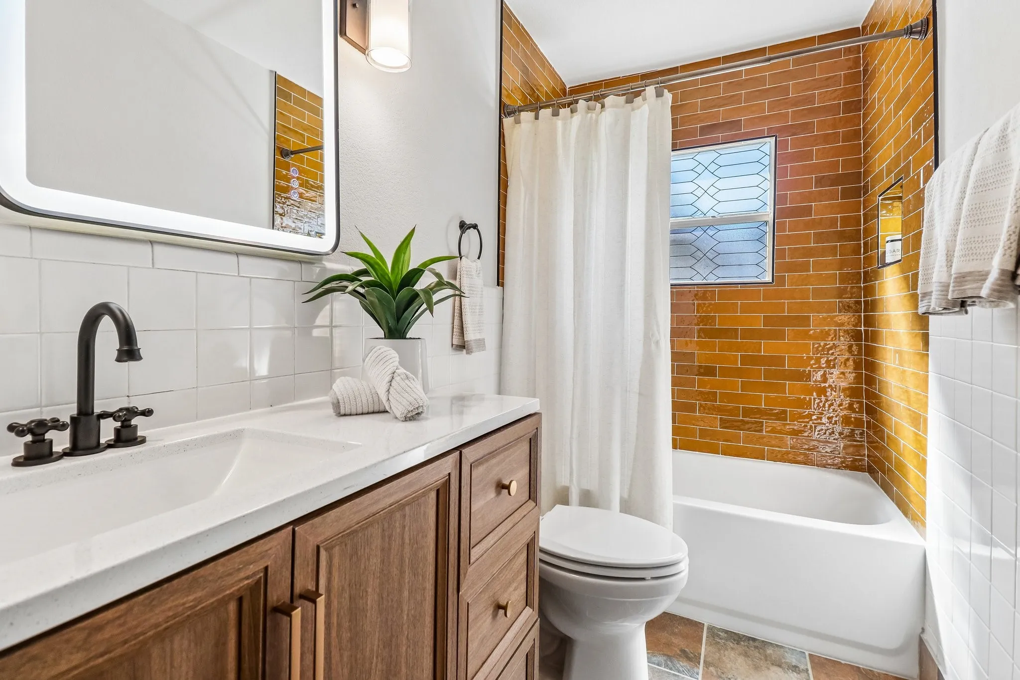 Wood-finish vanity with an integrated sink and matte black faucet