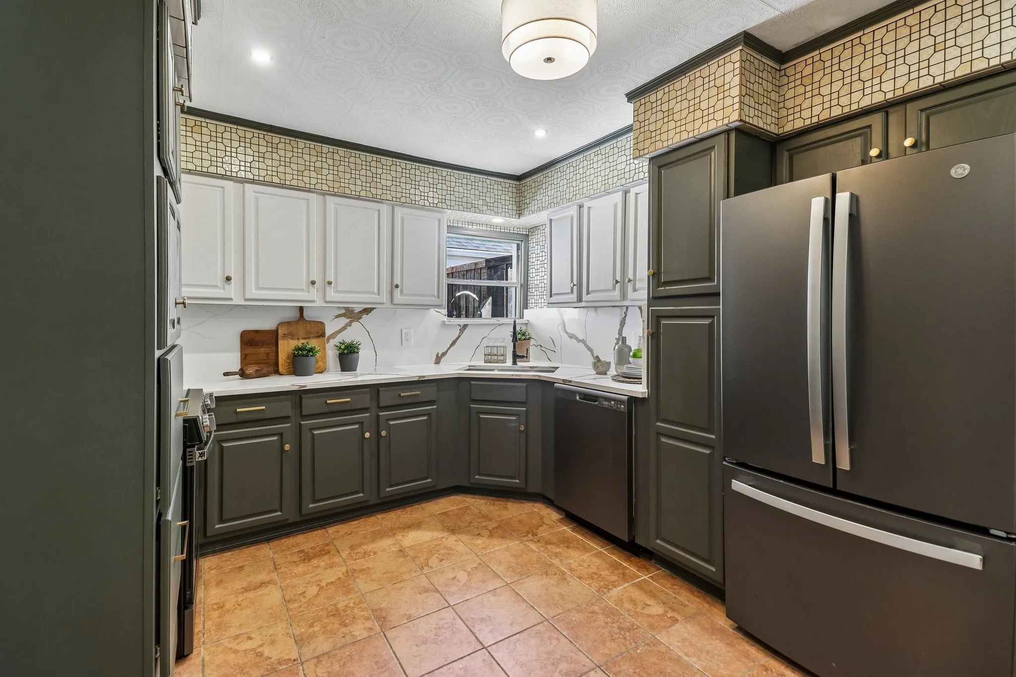 Matte finish appliances, two-tone cabinetry with gold-tone hardware, tile flooring, corner sink, and recessed lighting