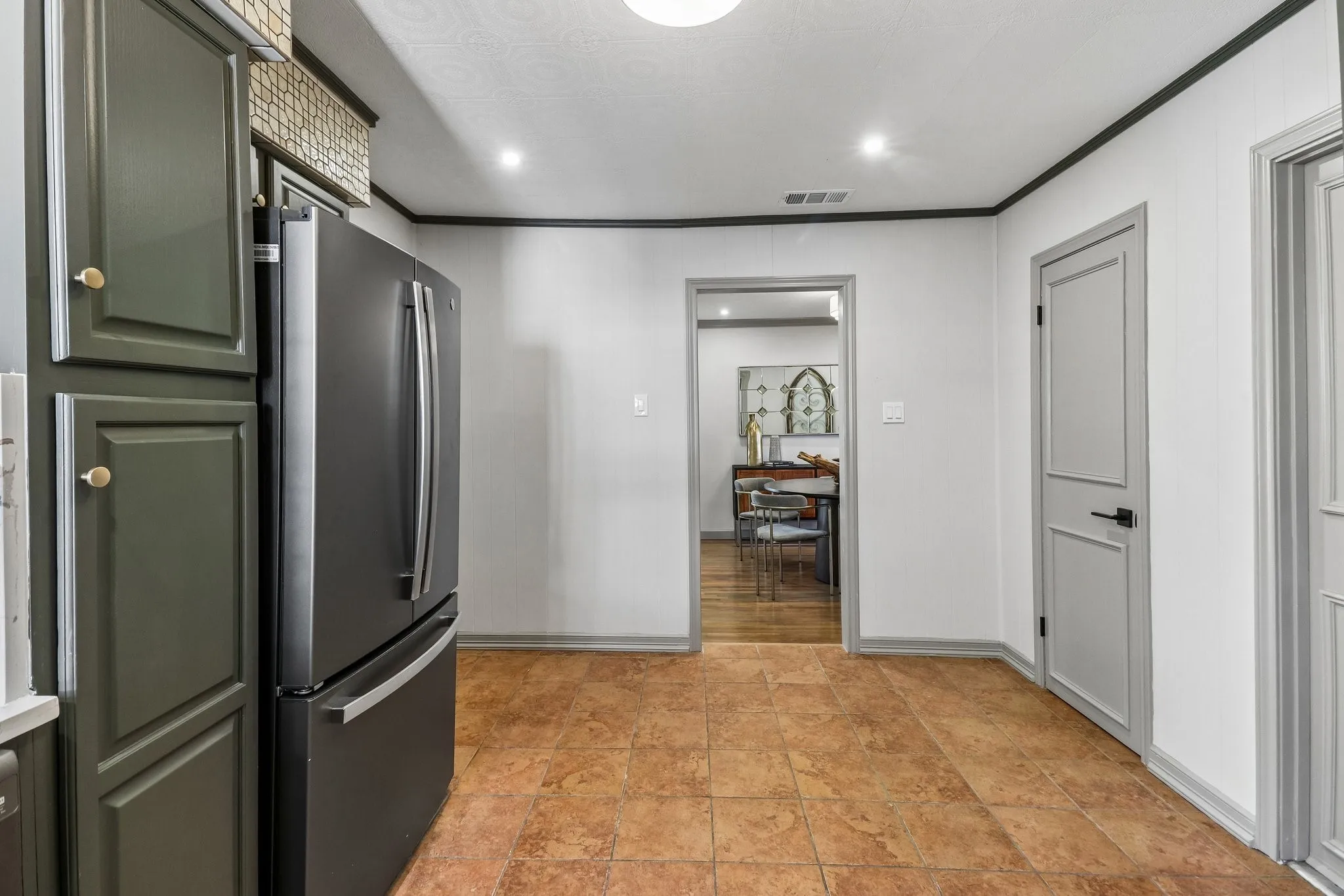 Tile flooring, recessed lighting, panel doors, and contrasting trim details