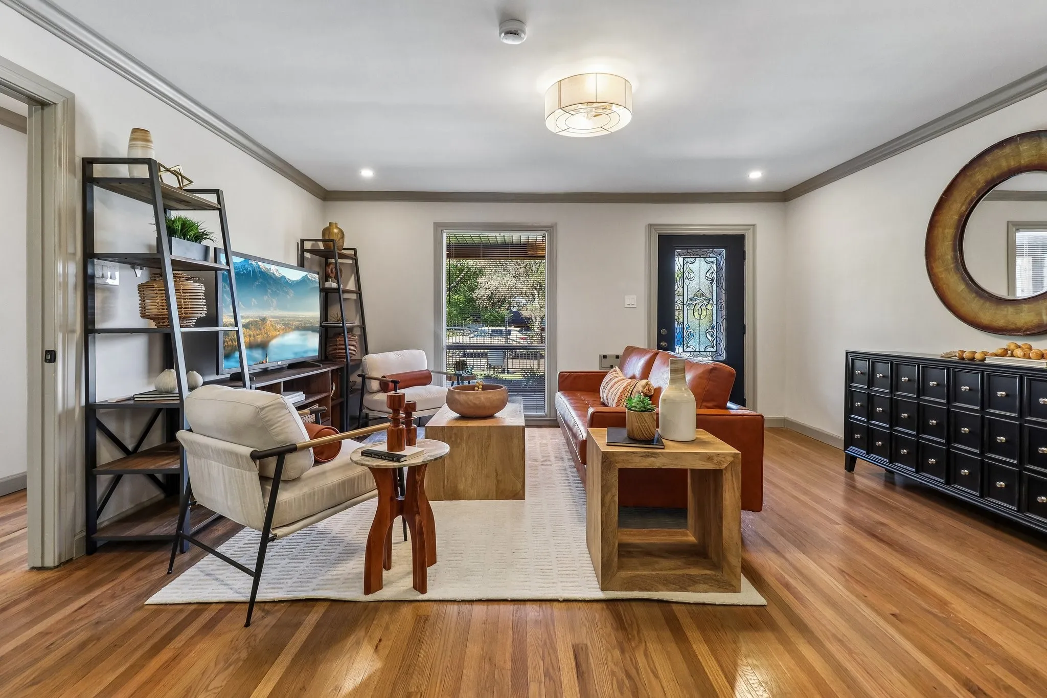 Hardwood flooring, recessed lighting, crown molding, modern light fixture, and a decorative entry door