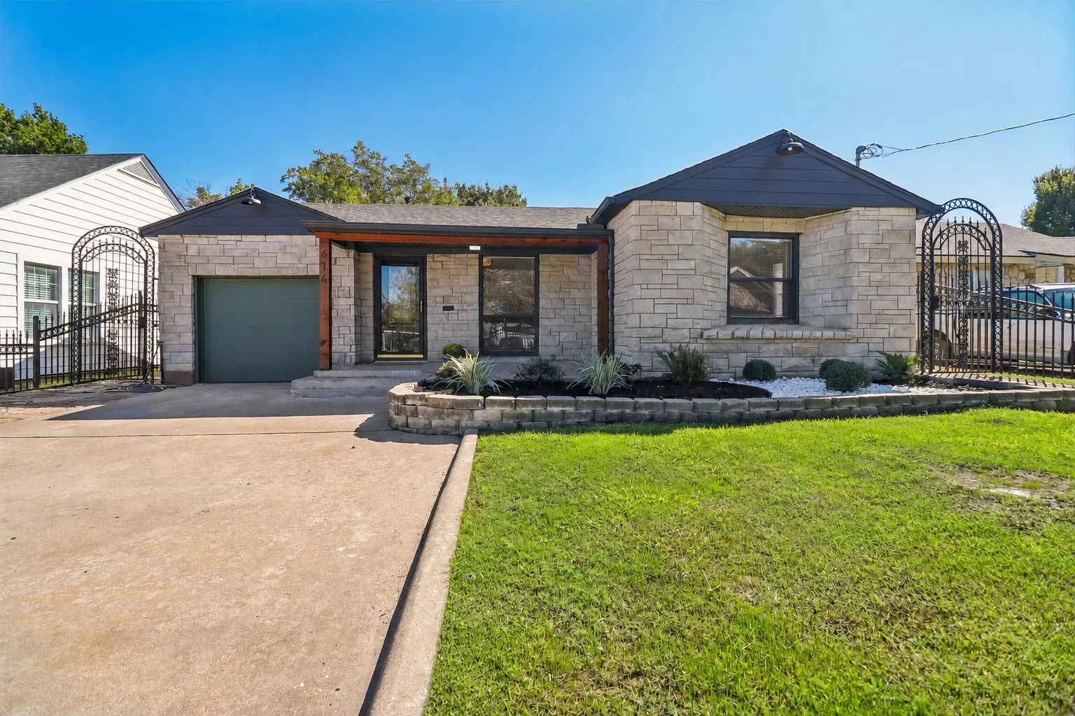 Stone facade with dark trim accents, covered entry, and a single-car garage
