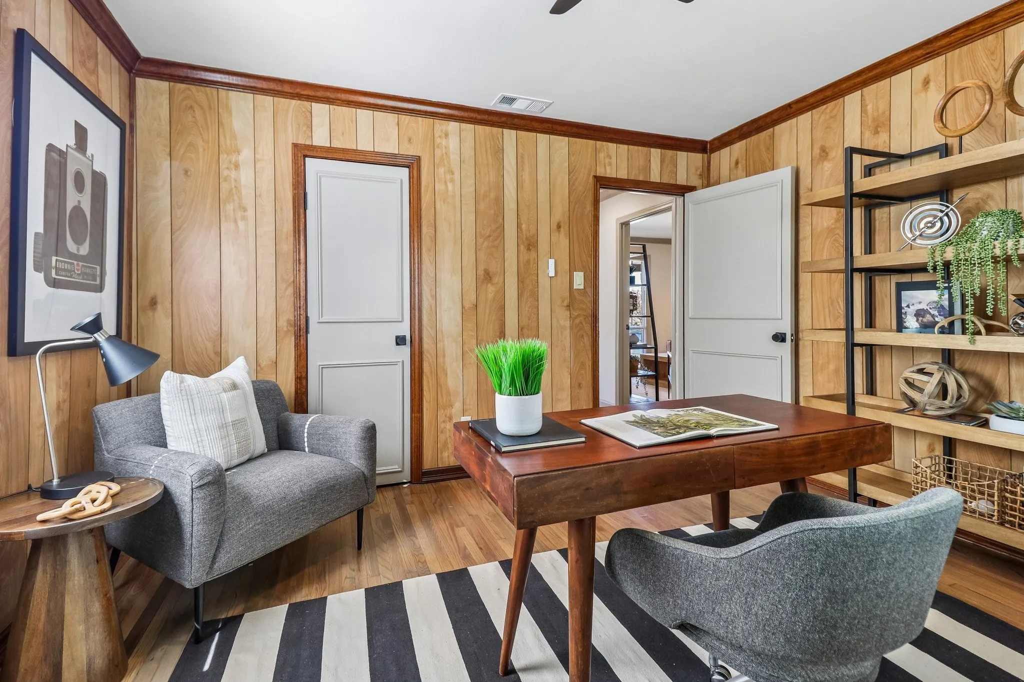 Wood-finish paneling and trim throughout, ceiling fan, and wood-finish flooring