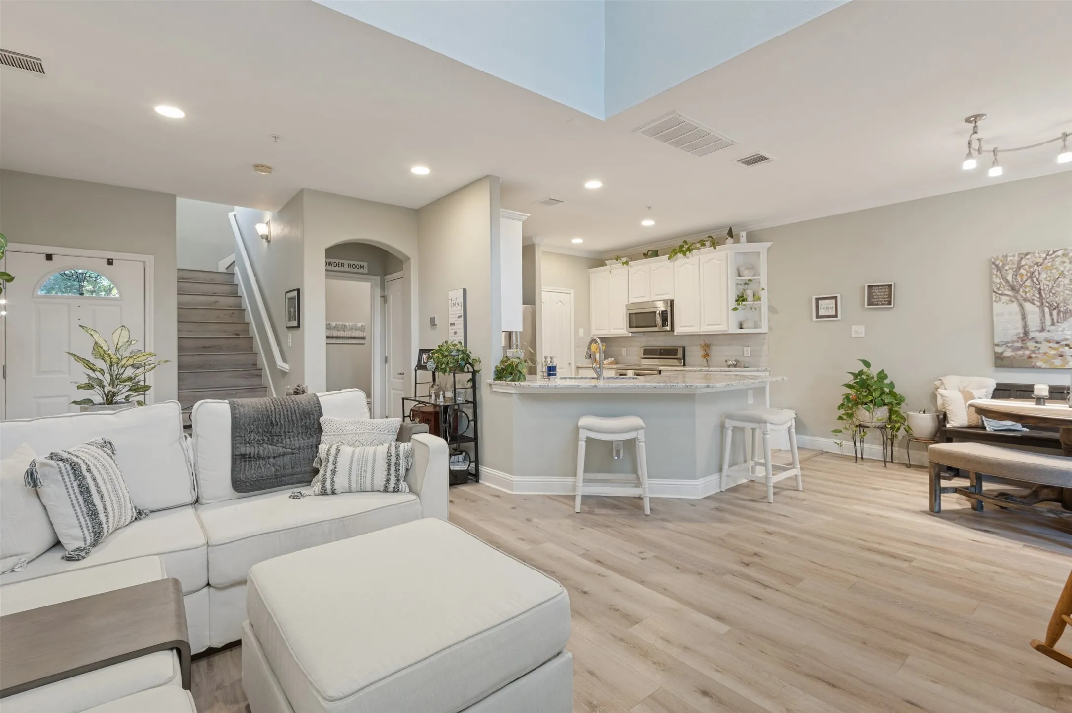 Beautiful living, kitchen, dining area with Granite breakfast bar, SS appliances, freshly painted cabinets, and cozy dining area