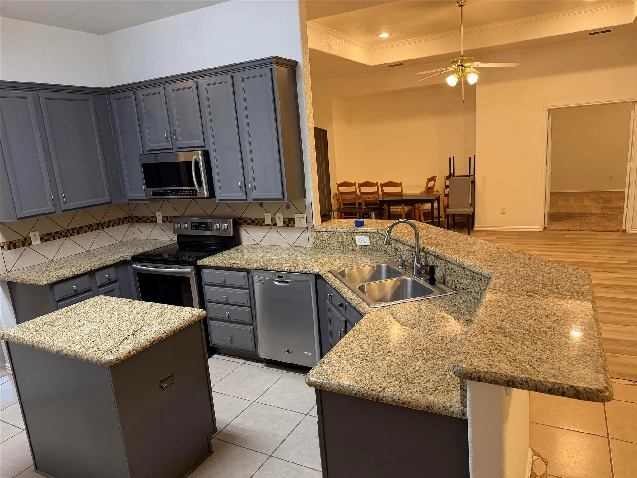 Island with Beautiful Granite and backsplace with stainless steel appliances
