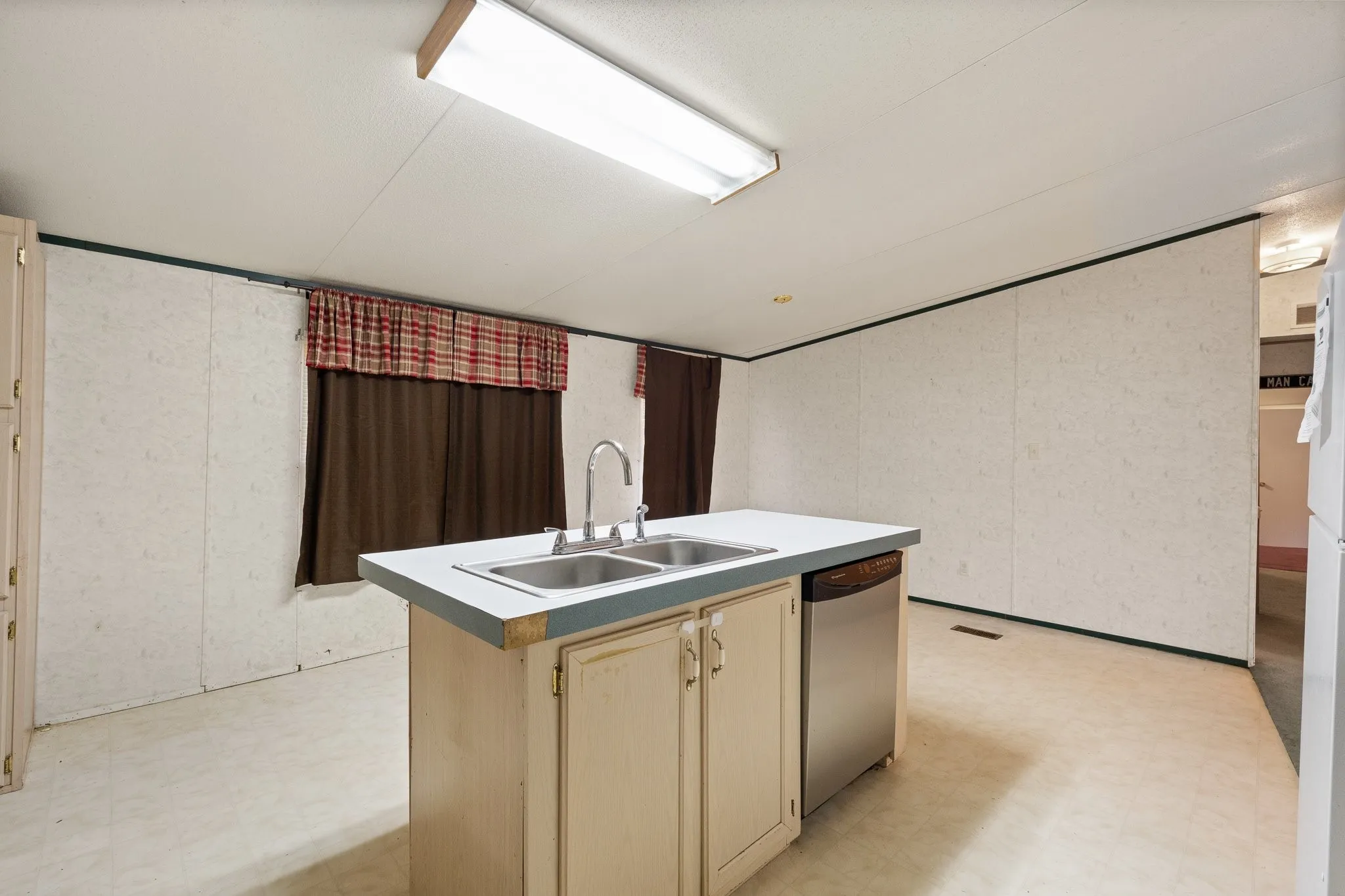 Island with sink and dishwasher along with windows for natural lighting and eat in dining.