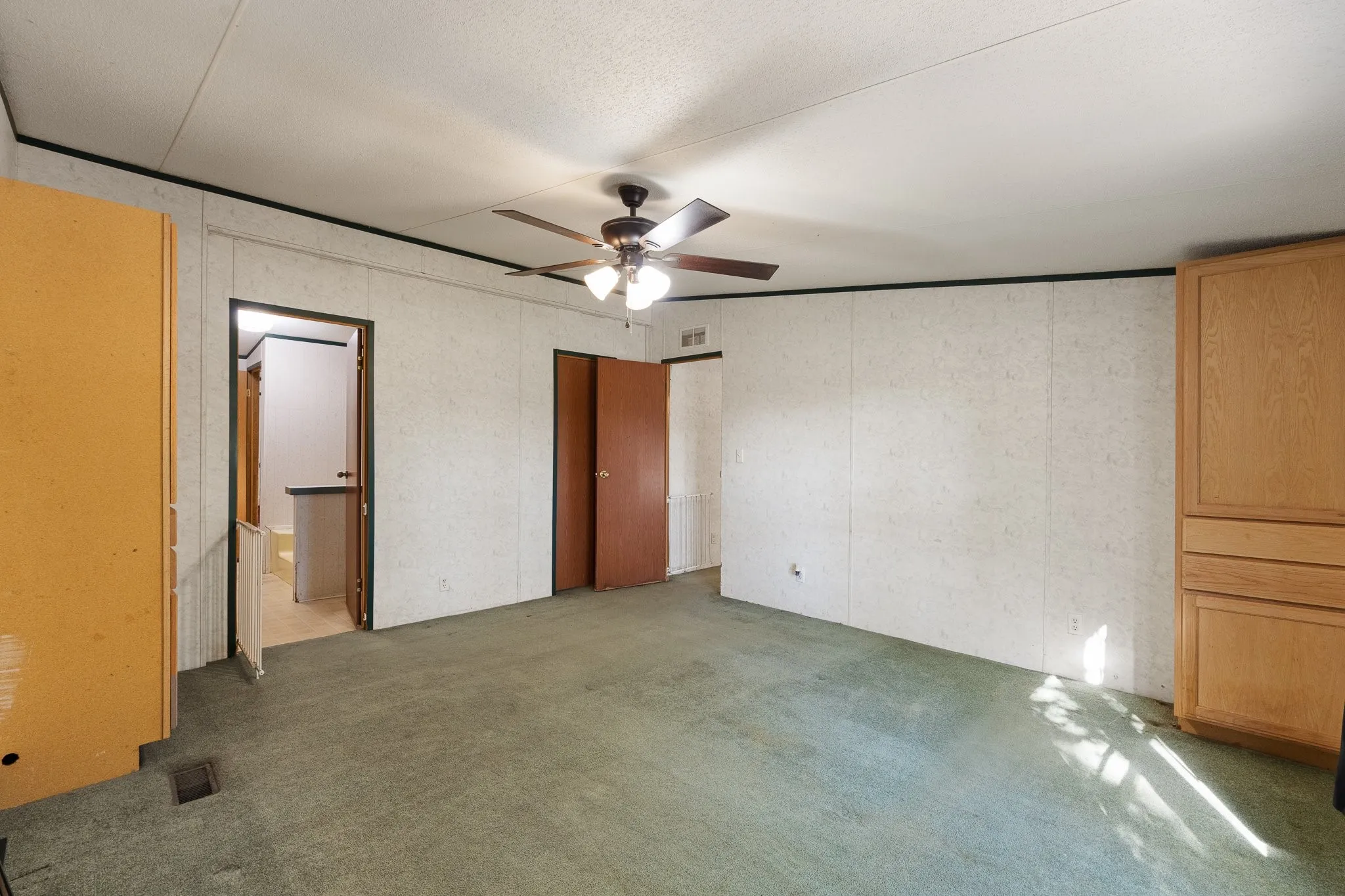 Master bedroom with cabinetry for storage, walk in closet, and en suite bath.