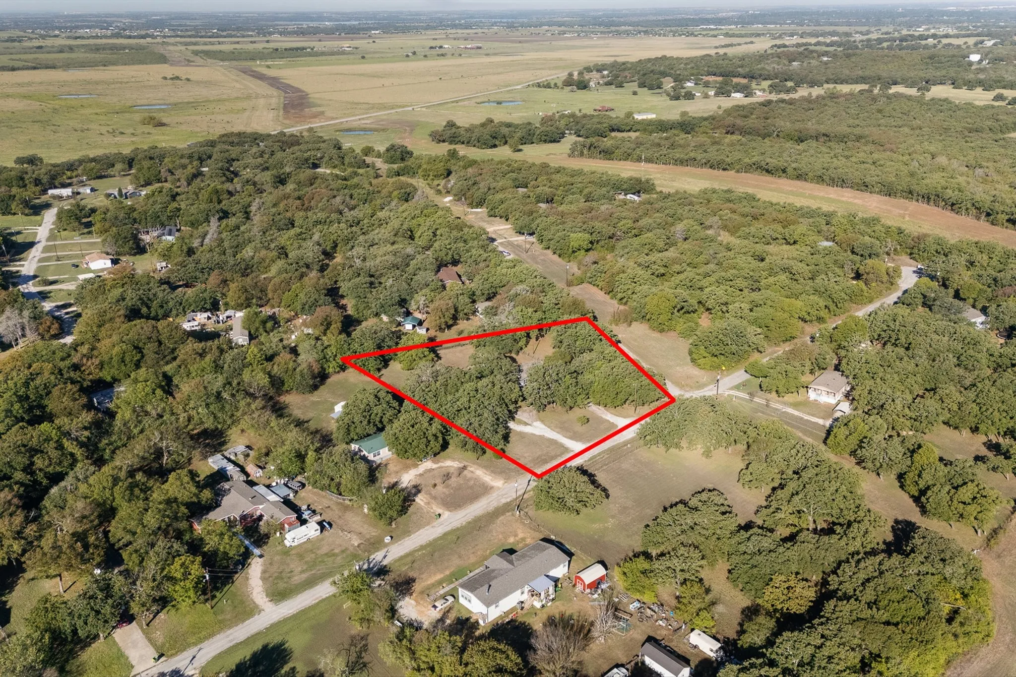Aerial view of home outlined, surrounded by trees and farmland.