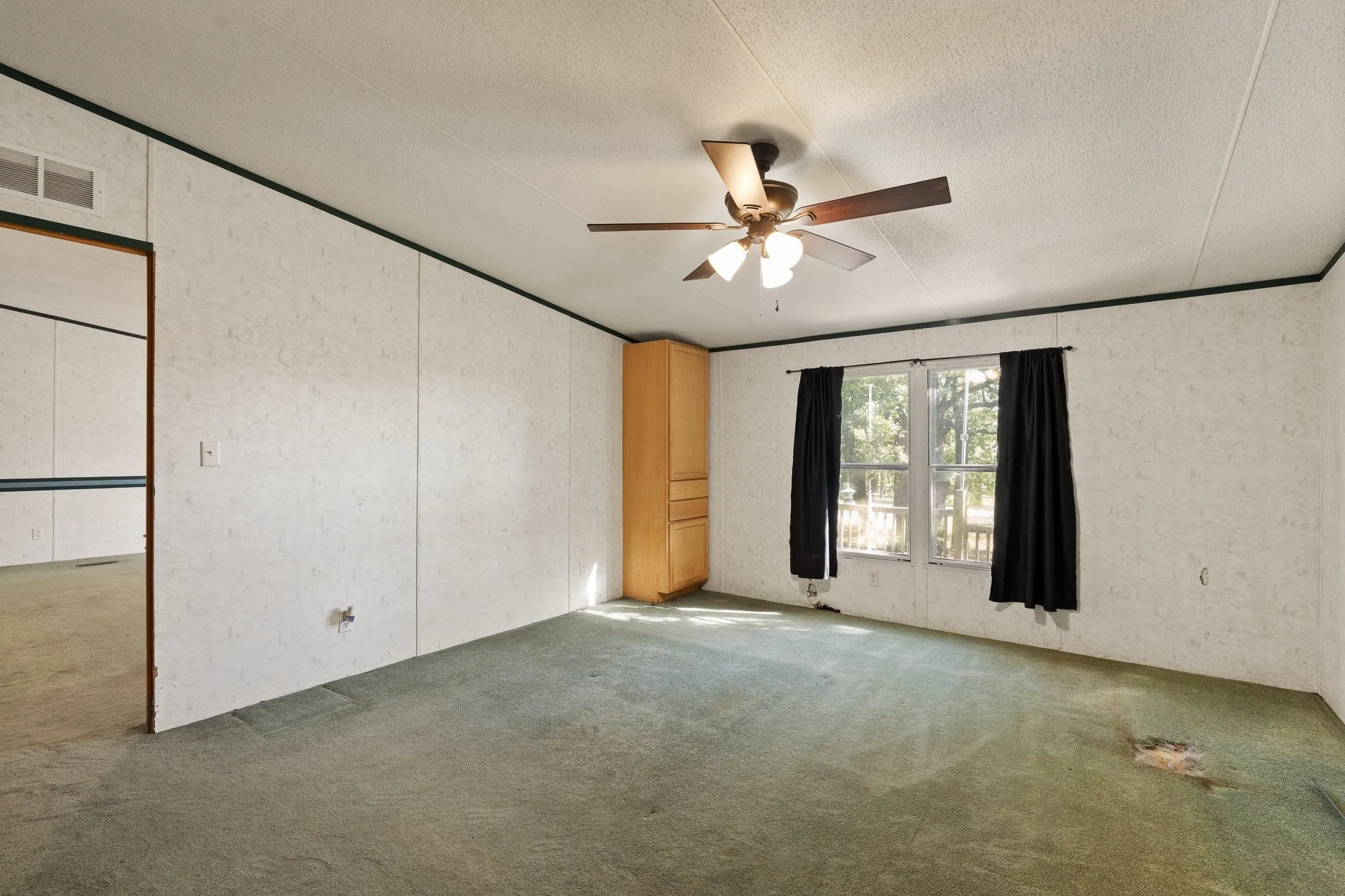 Master bedroom with cabinetry for storage, ceiling fan, and windows for natural lighting.