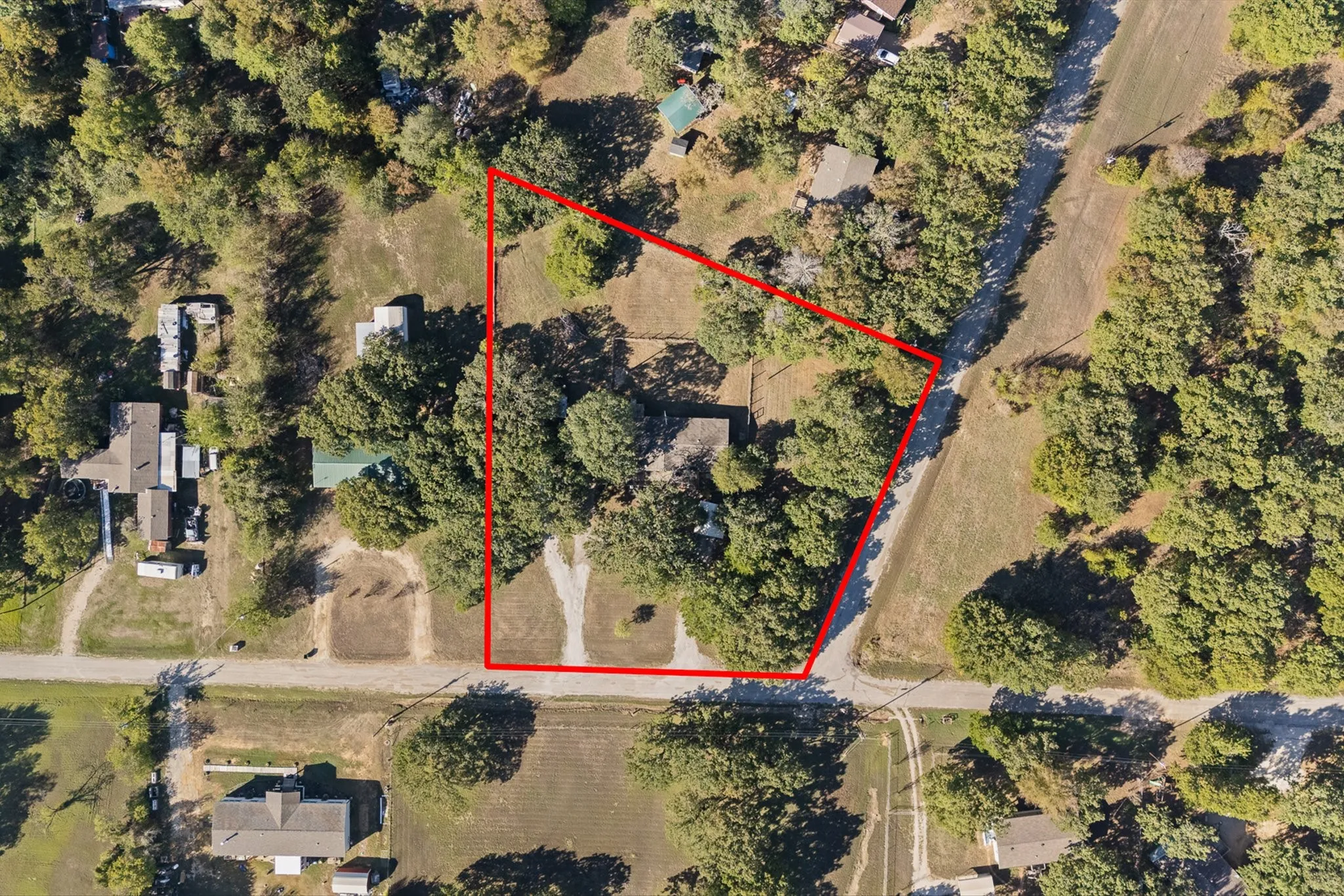 Aerial View of home surrounded by lots of mature trees for privacy and farmland.