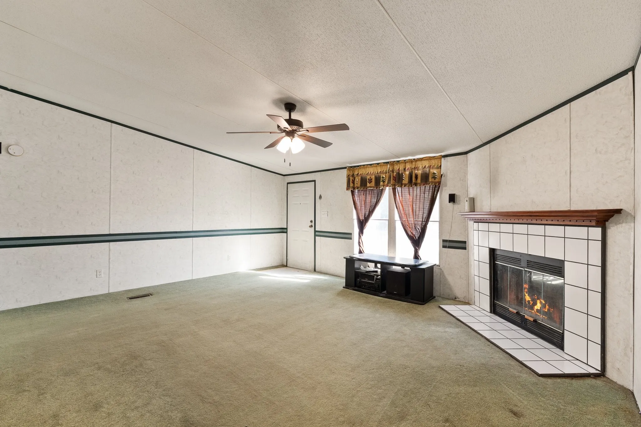 Living Area with tiled fireplace and windows for natural lighting.