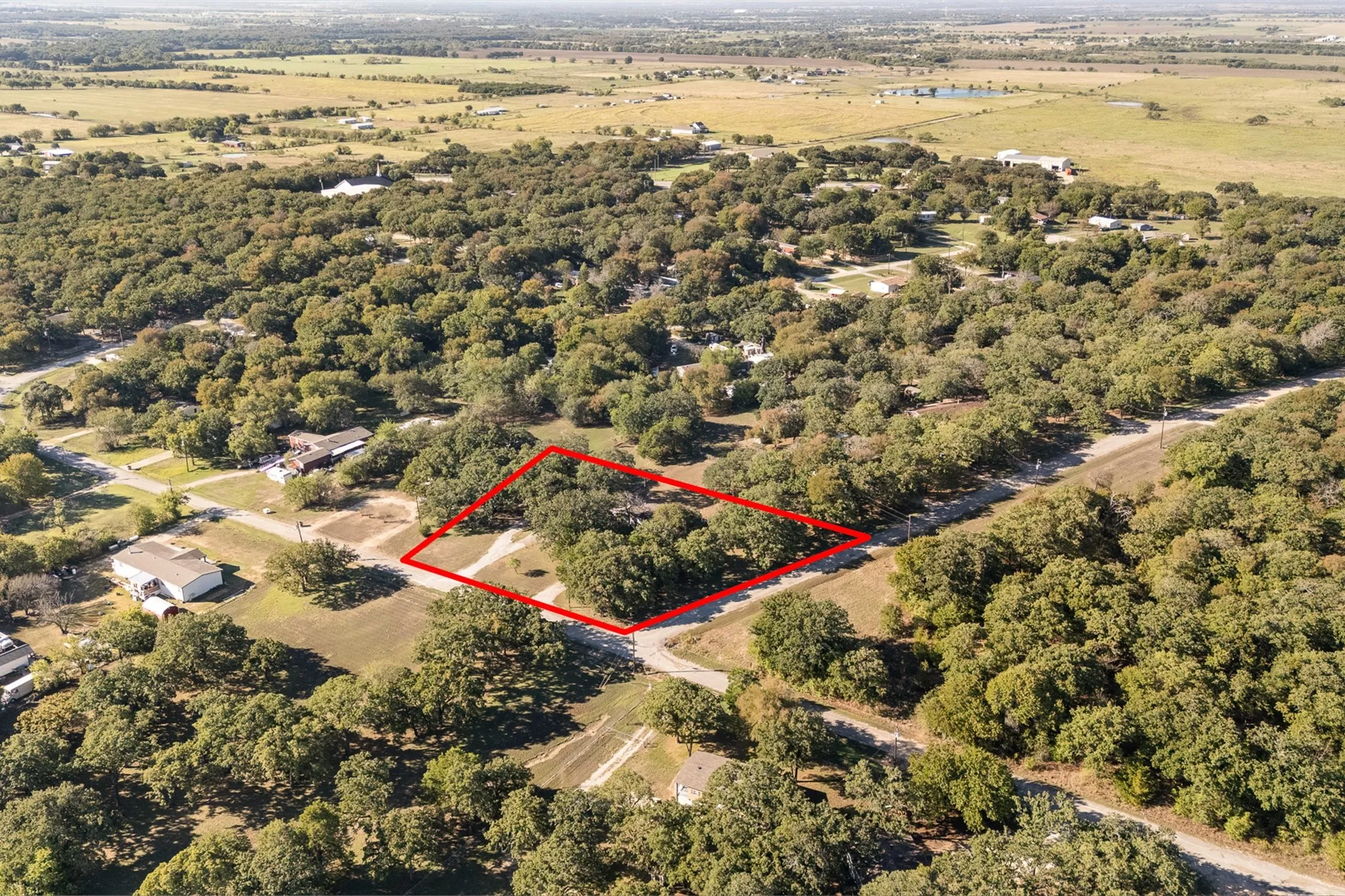 Aerial View of home surrounded by lots of mature trees for privacy and farmland.