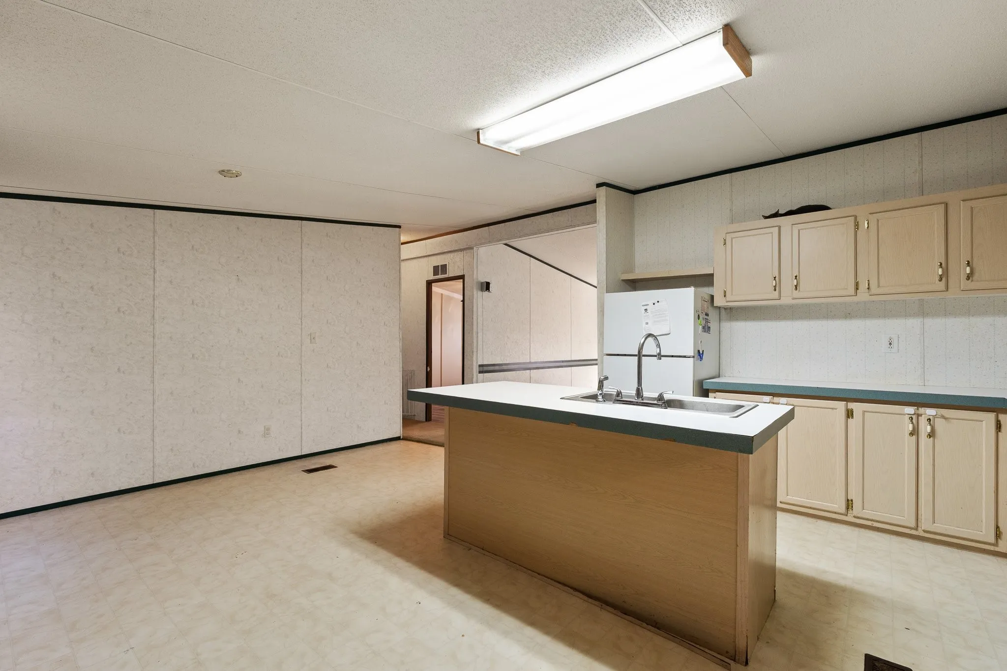 Kitchen with island, light colored cabinetry for storage, and eat in dining room.