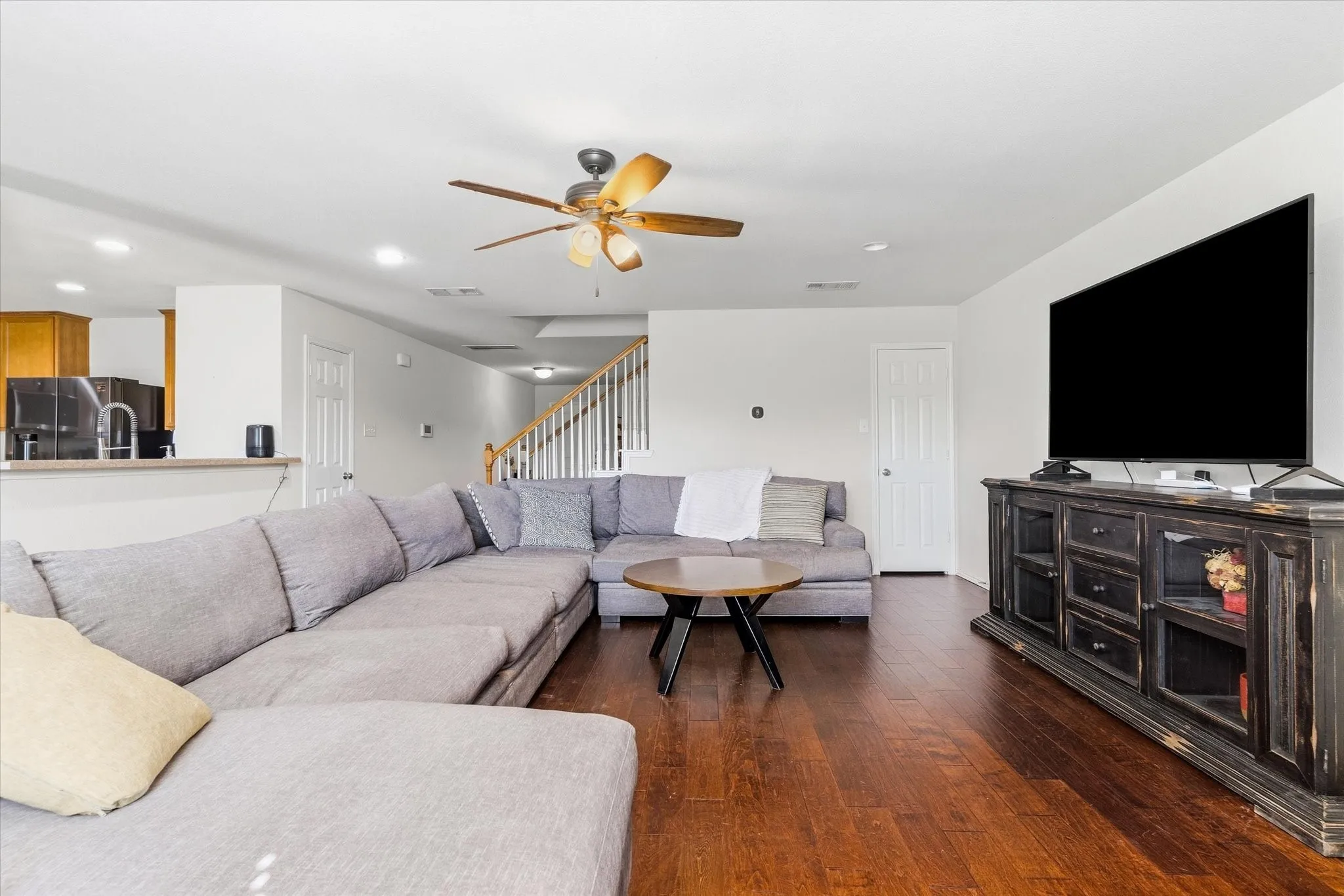 Wood-finish flooring throughout, featuring a ceiling fan with light fixture
