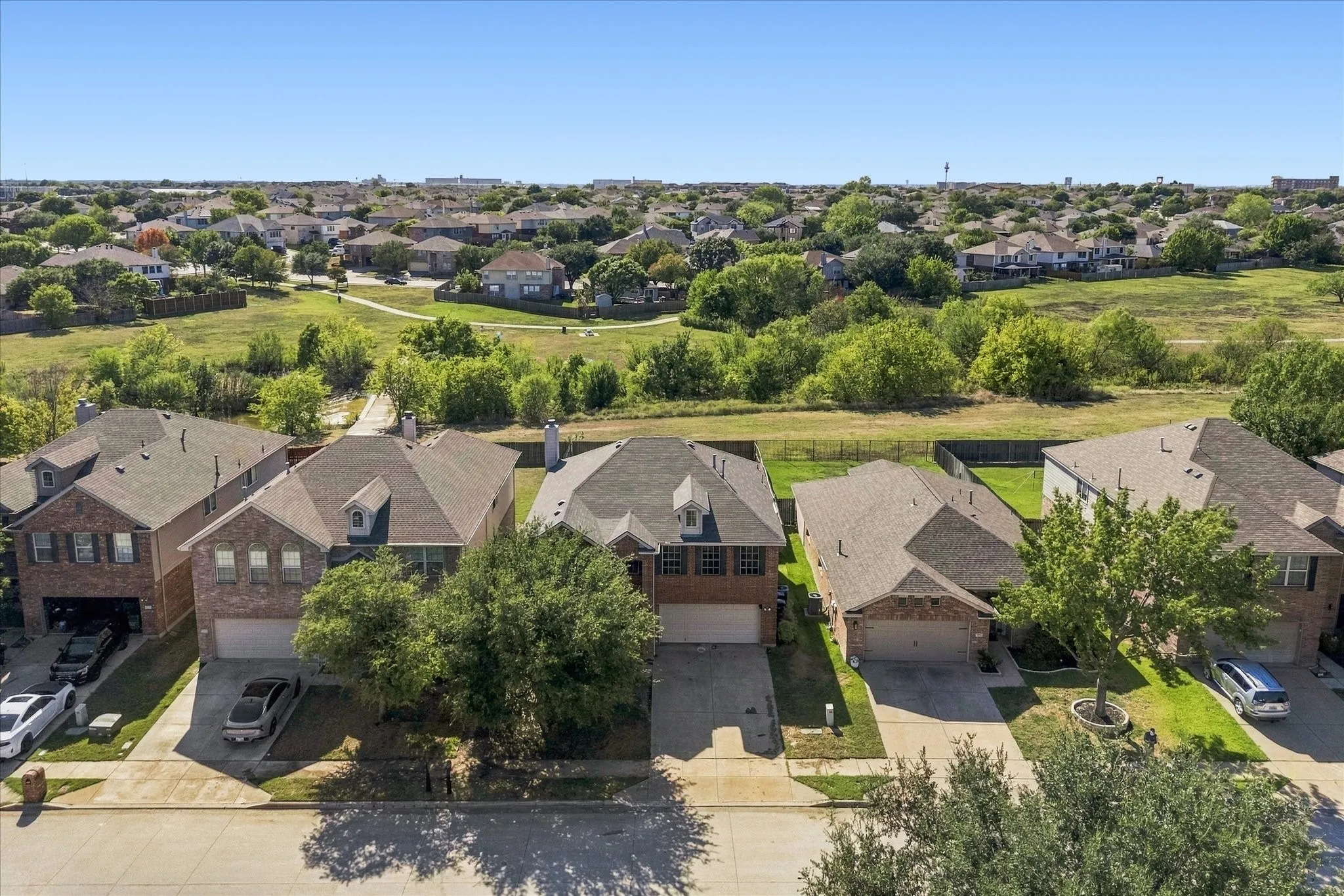 Residential neighborhood with manicured green spaces and mature trees
