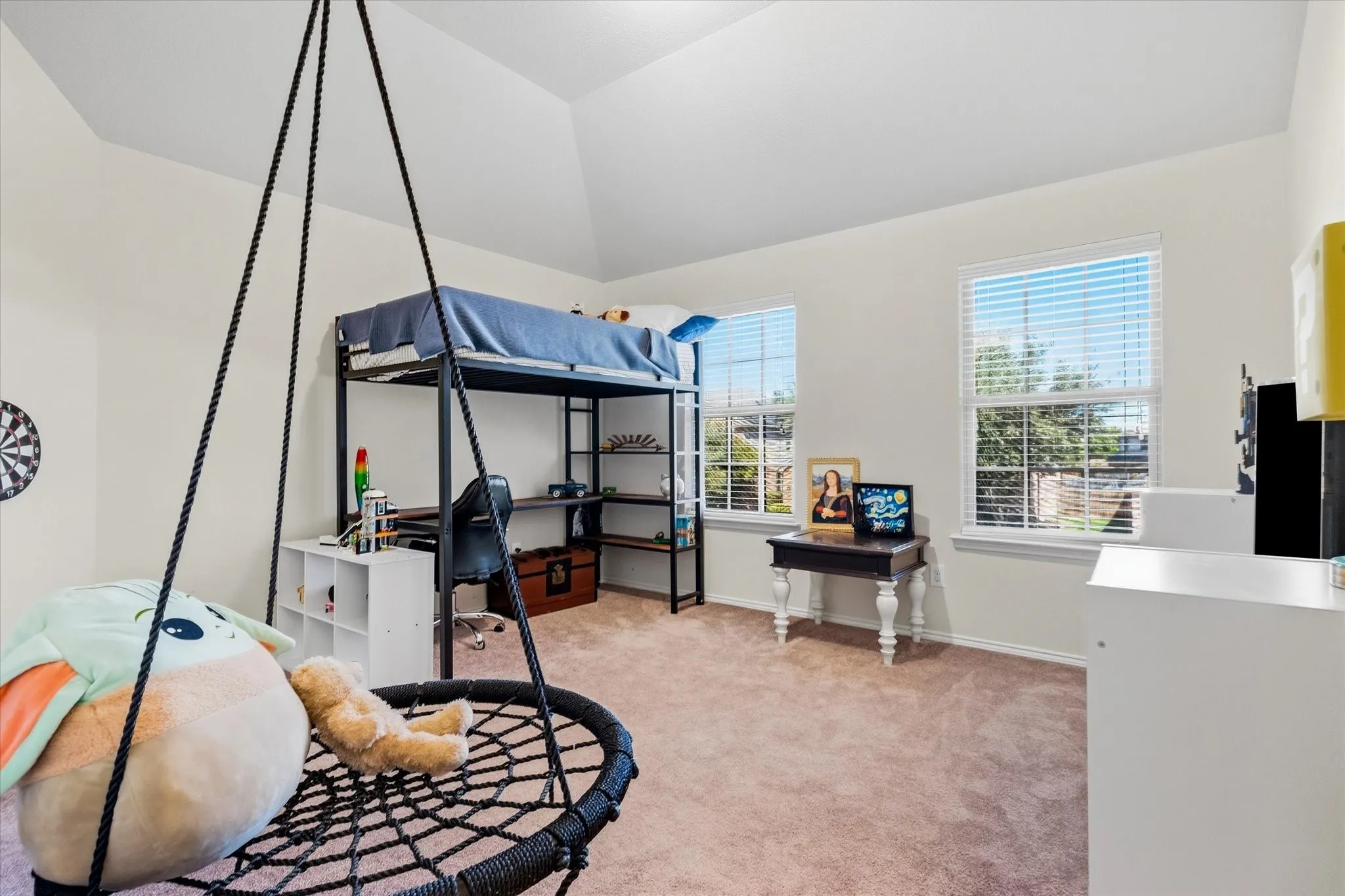 Vaulted ceiling, two windows with blinds, light-colored walls, and neutral carpet flooring