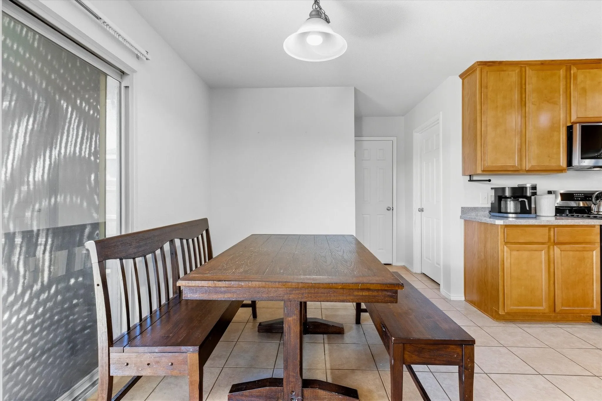 Kitchen featuring wood cabinetry, light-toned countertops, and tile flooring